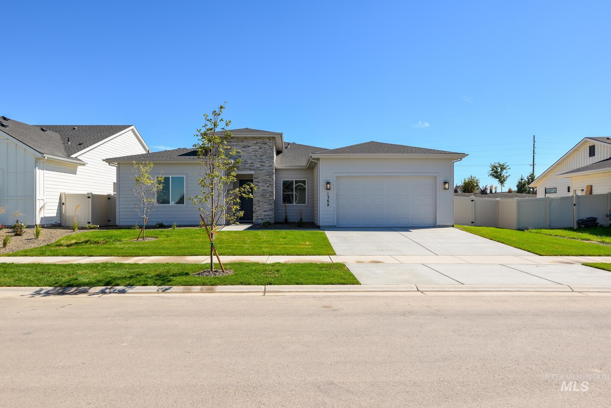 View of front of property featuring driveway, an attached garage, and roof with shingles