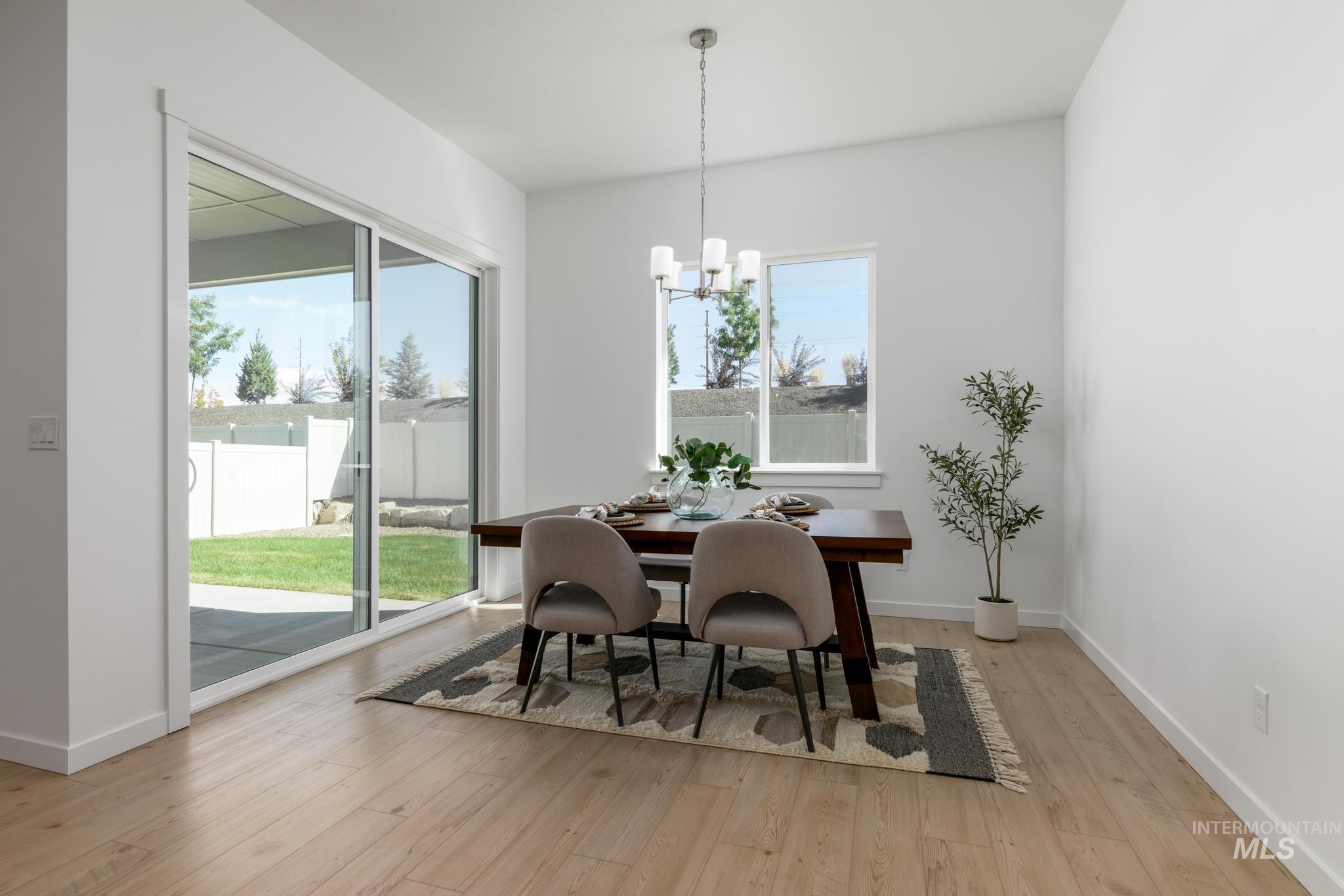 Dining space with light wood-type flooring and a chandelier