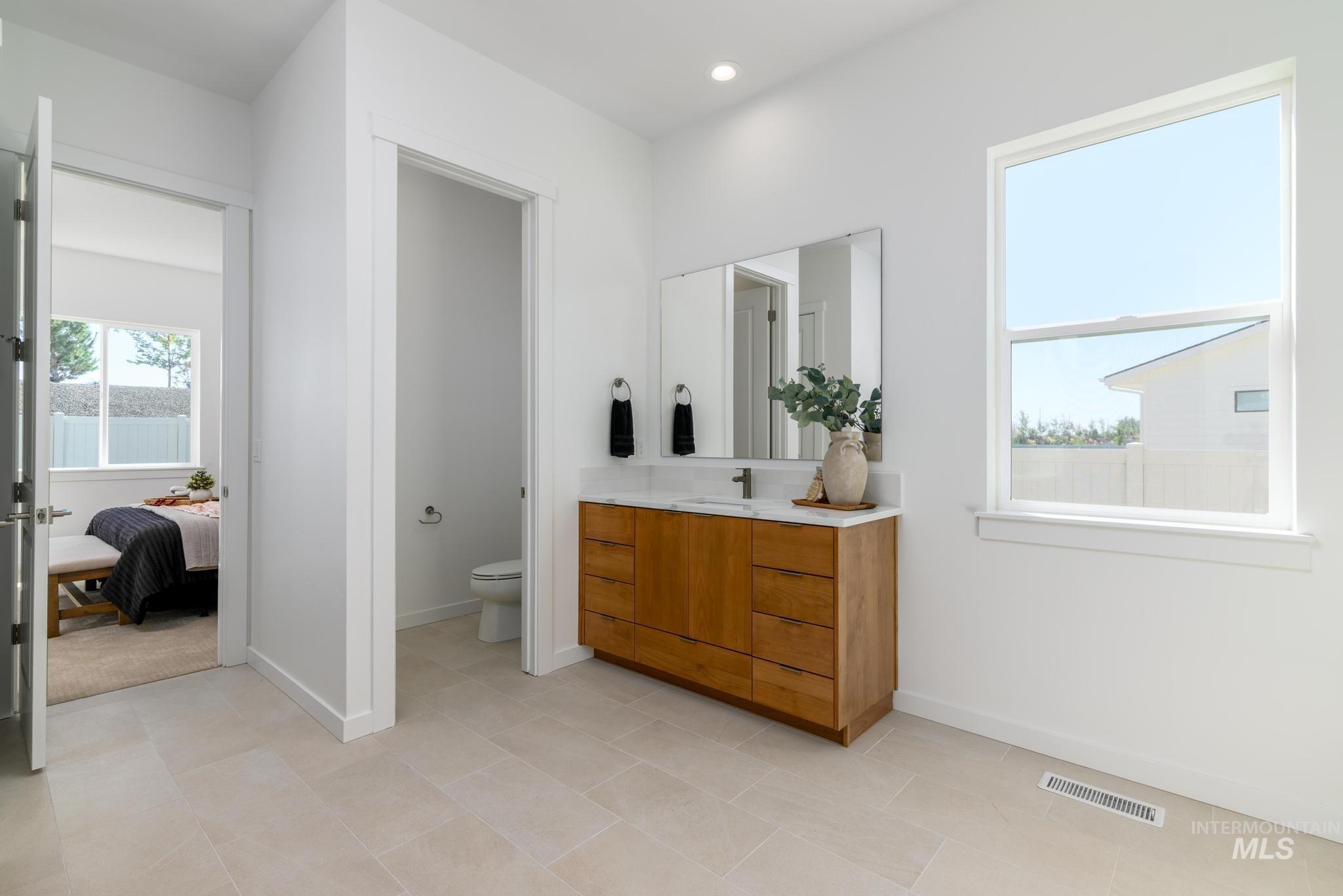 Full bath with vanity, recessed lighting, and connected bathroom