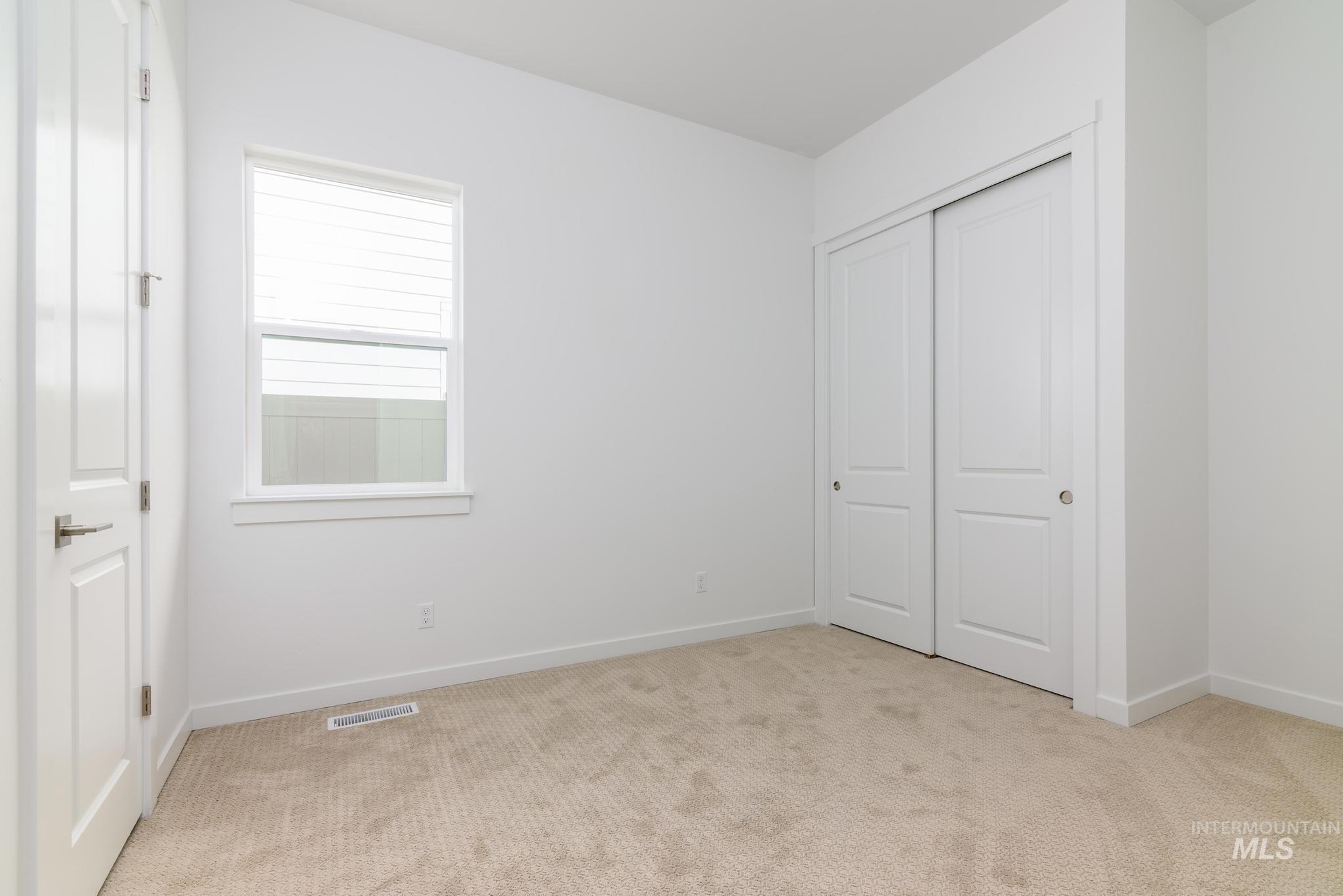 Unfurnished bedroom featuring light colored carpet and a closet