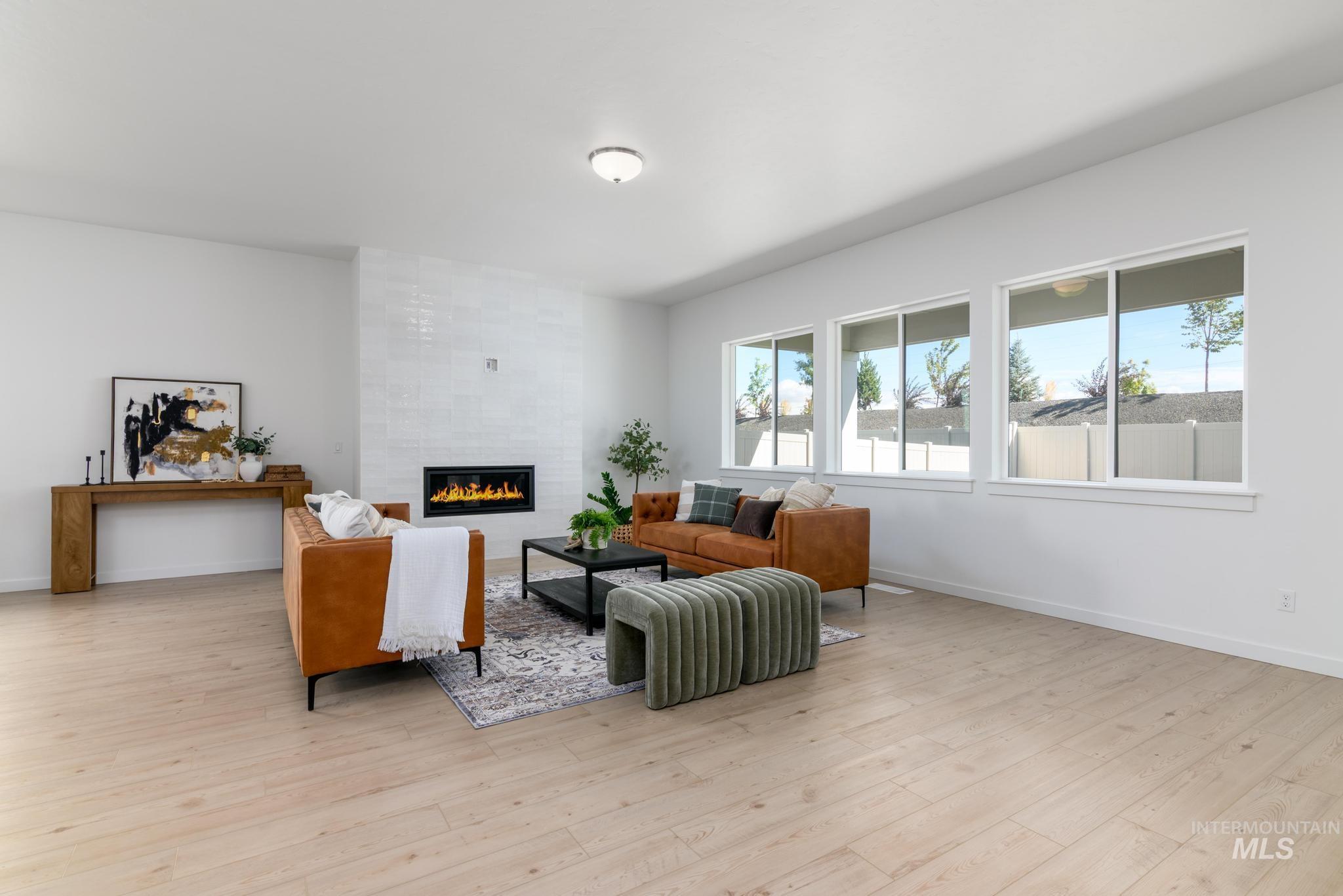 Living room with a tiled fireplace and light wood-style flooring