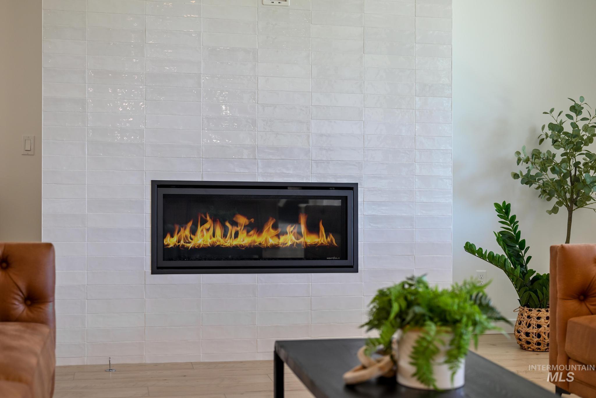 Detailed view of wood finished floors and a glass covered fireplace