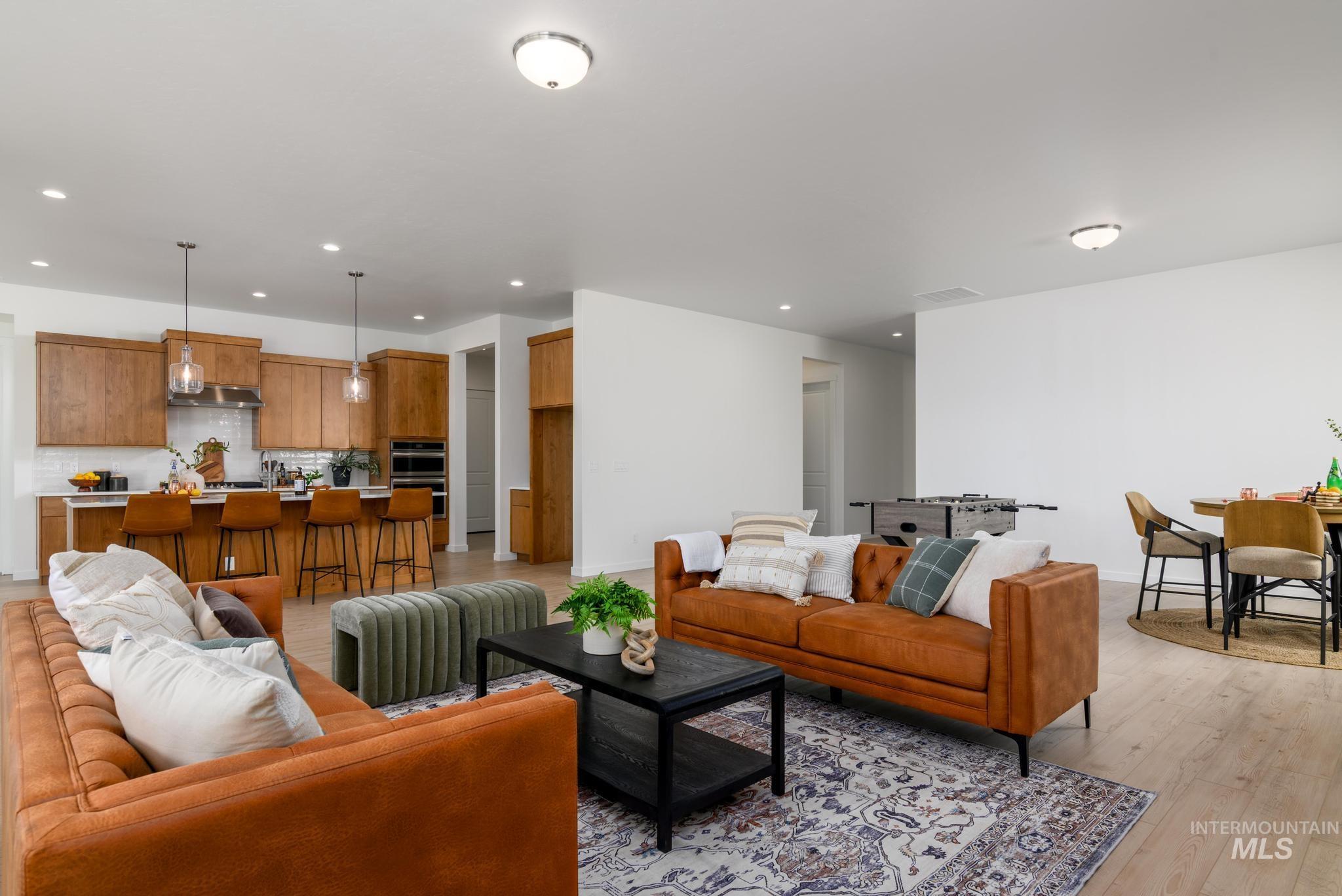 Living room with light wood finished floors and recessed lighting