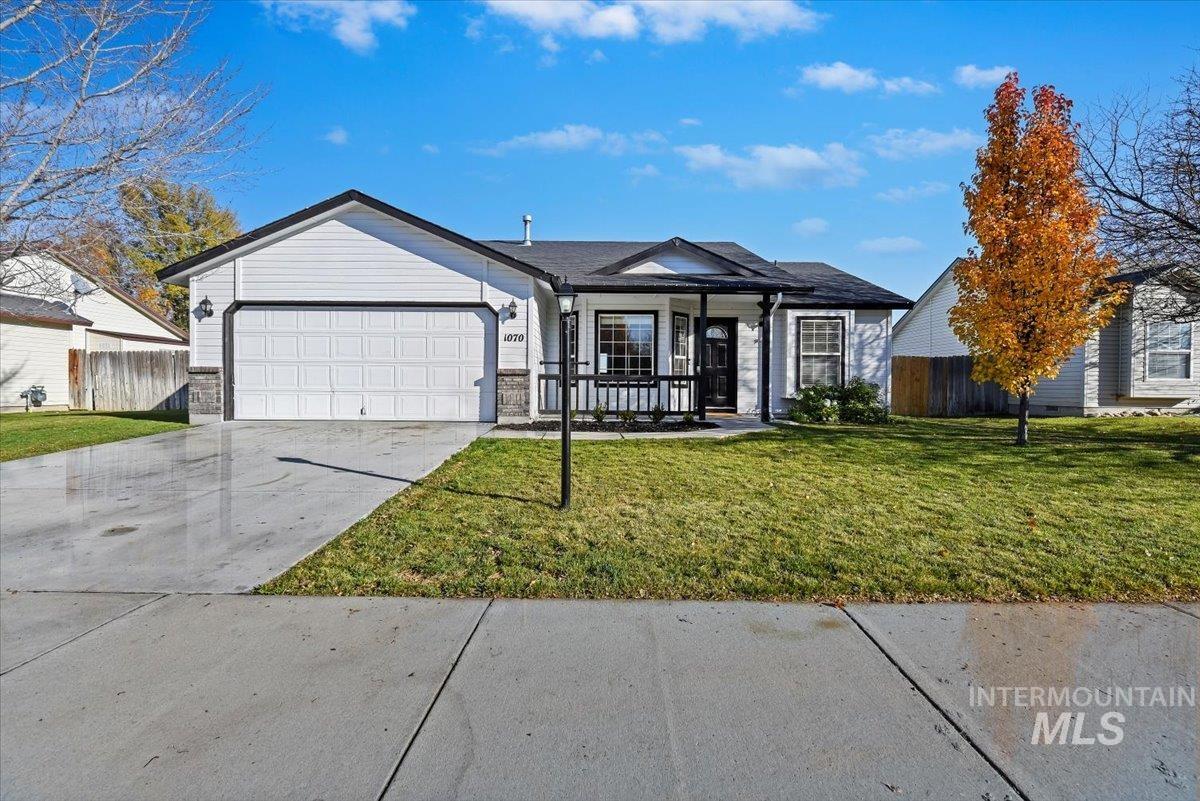 Ranch-style home with concrete driveway, a porch, and a garage