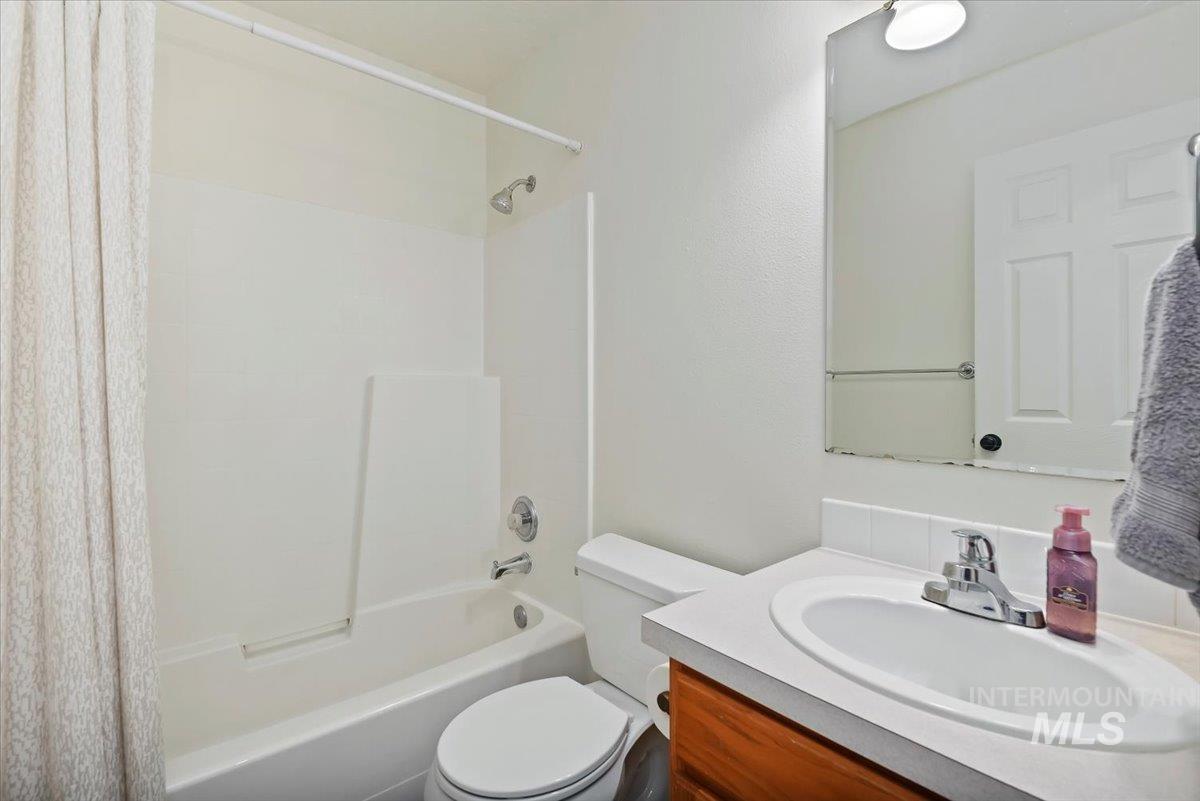 Bathroom featuring vanity and shower / bath combination with curtain