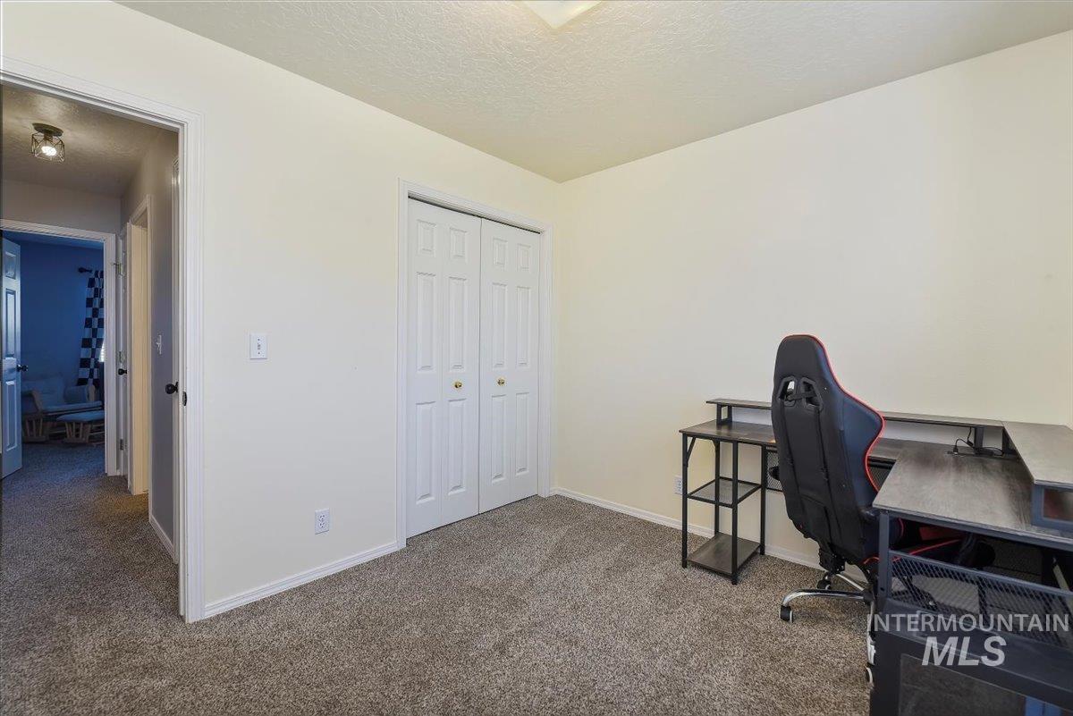 Office area with a textured ceiling and carpet