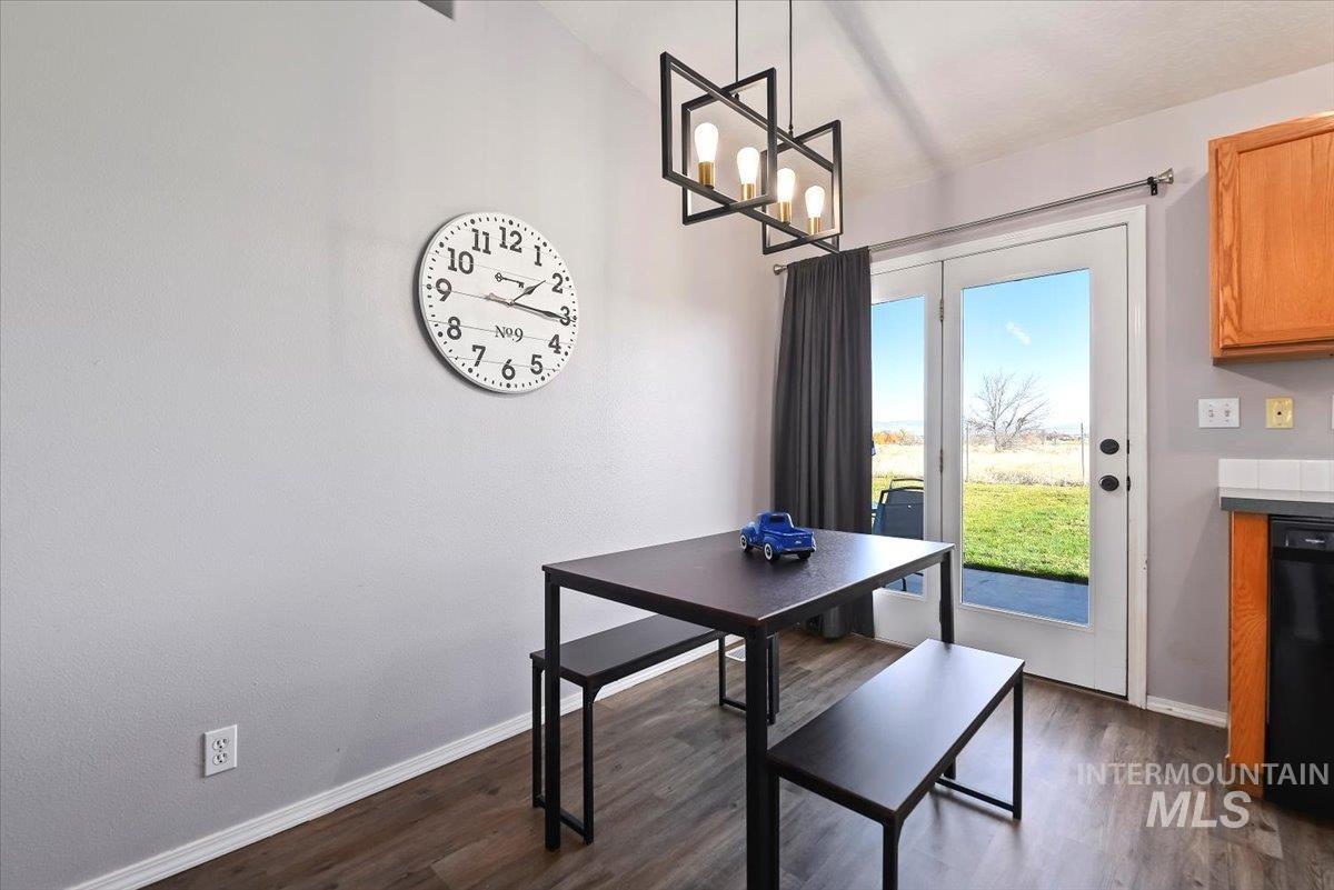 Dining room with dark wood-style floors and a chandelier