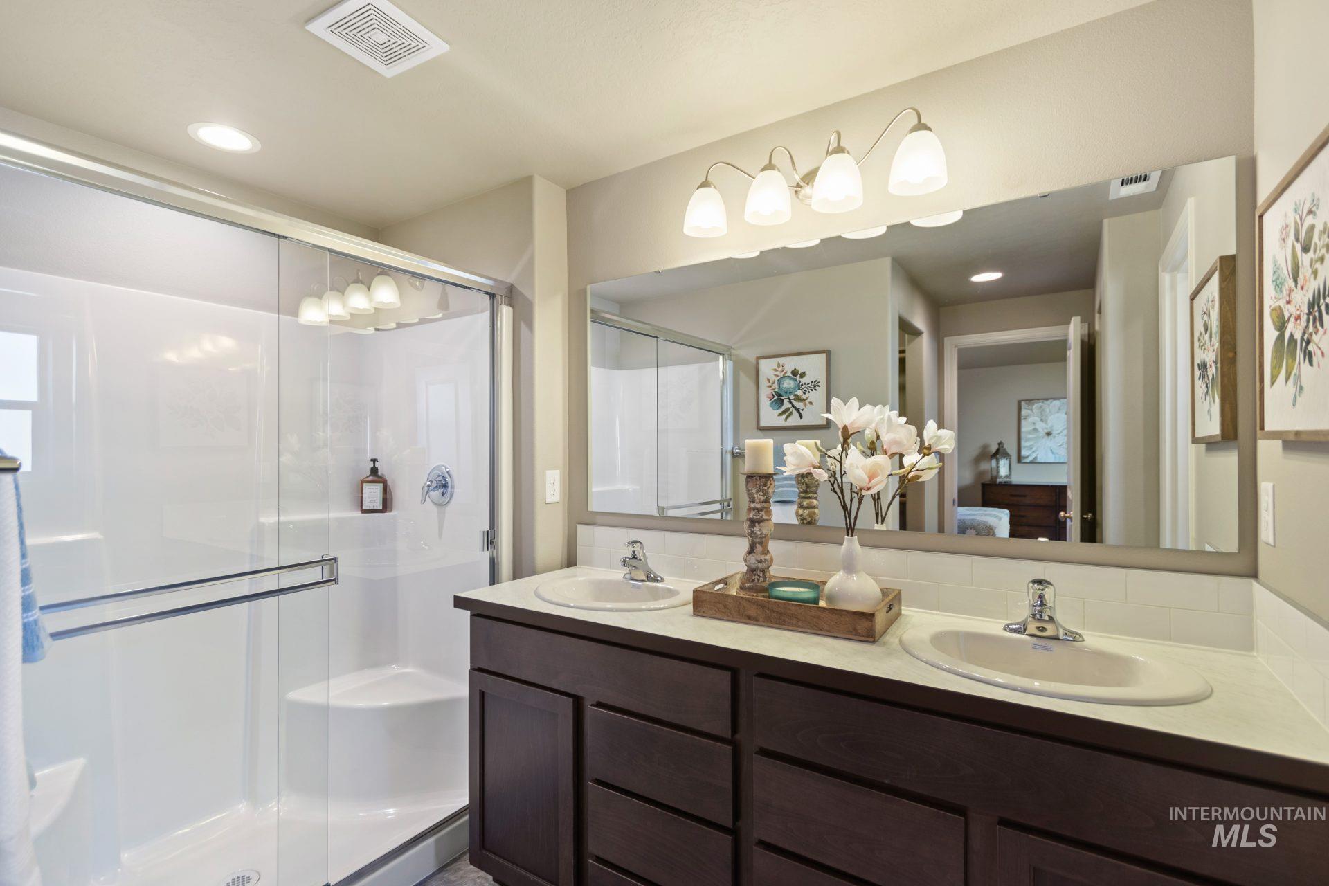 Ensuite bathroom with recessed lighting, double vanity, and a shower stall