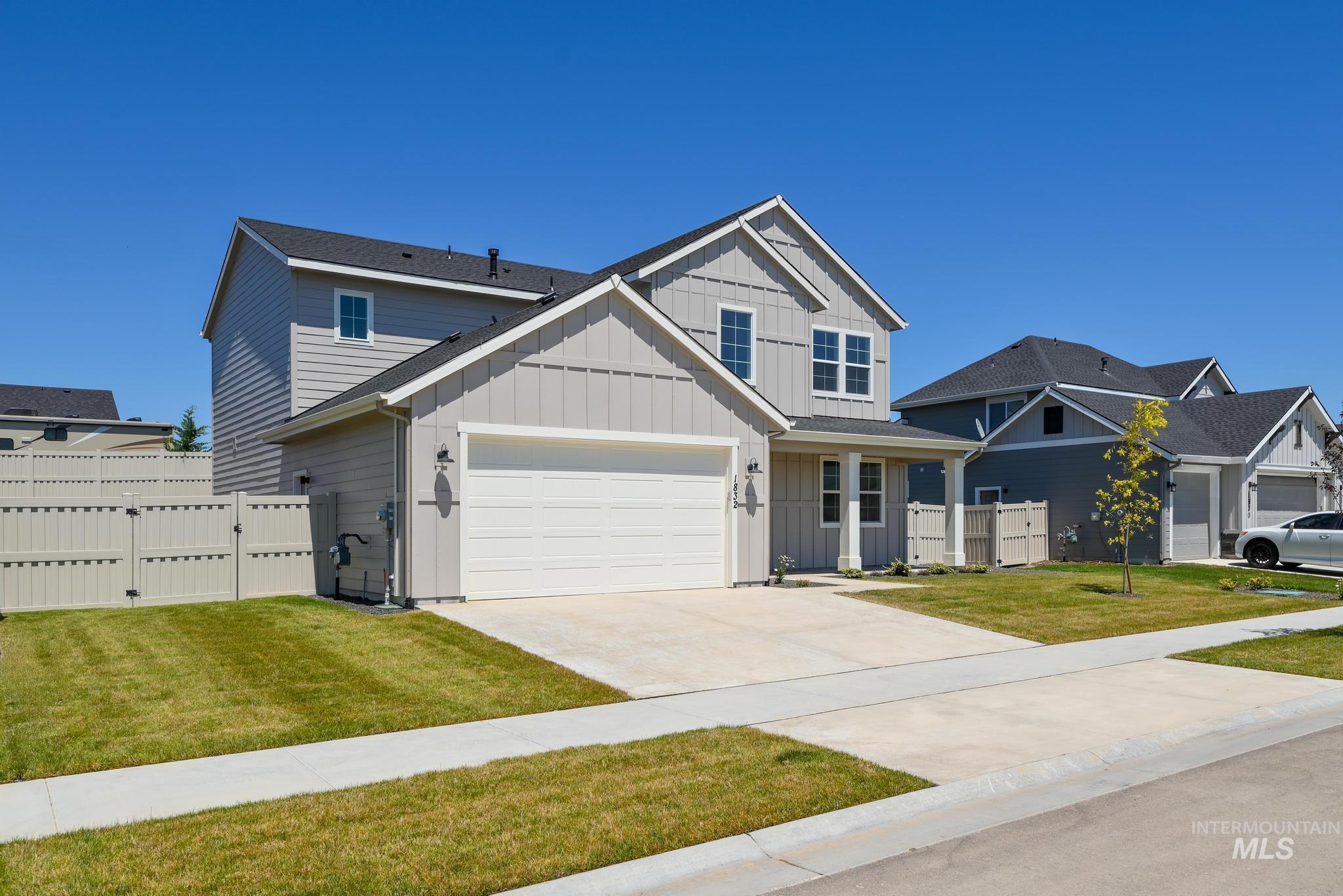 View of front of home featuring board and batten siding, a garage, and concrete driveway