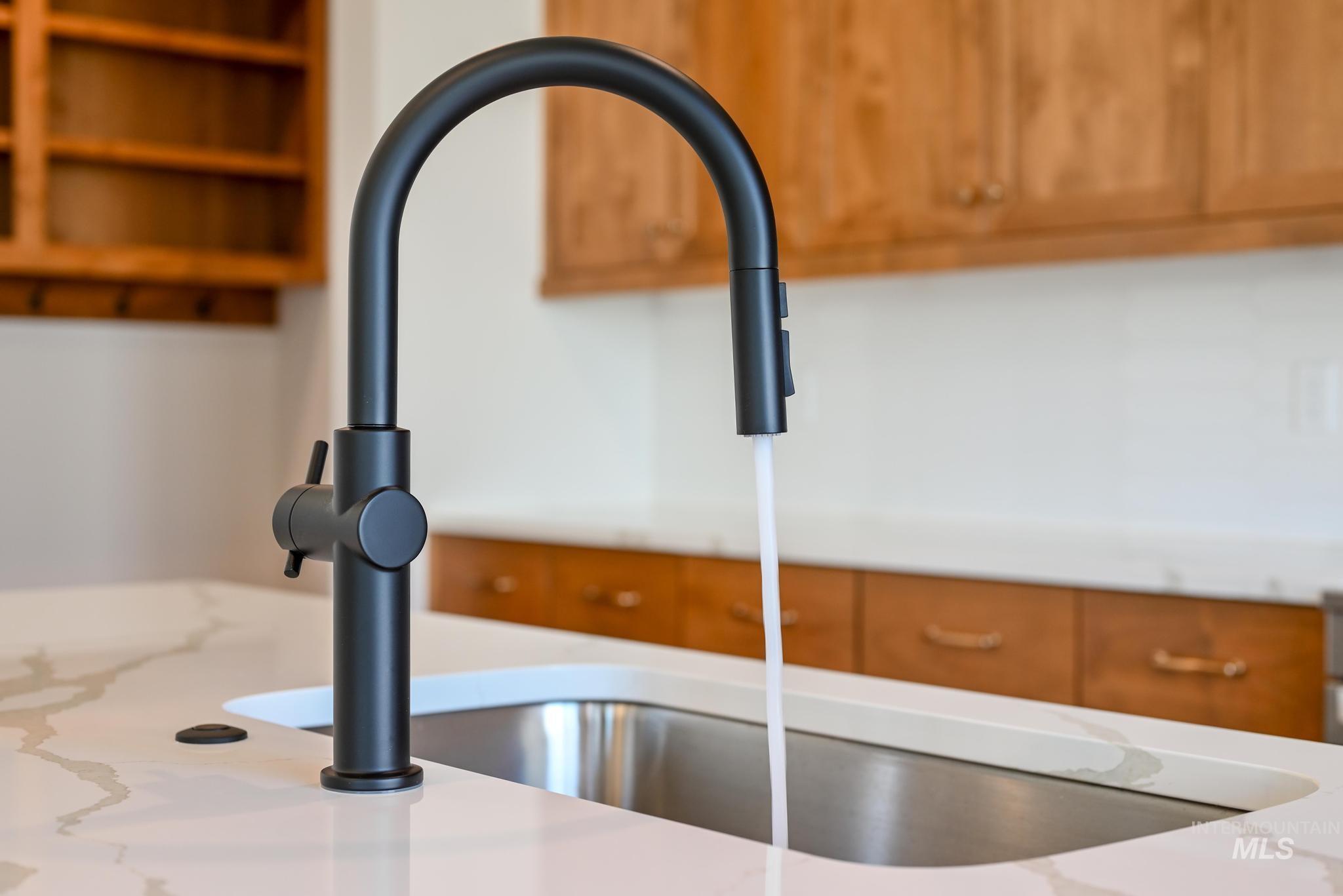 Kitchen view of brown cabinets and light stone countertops