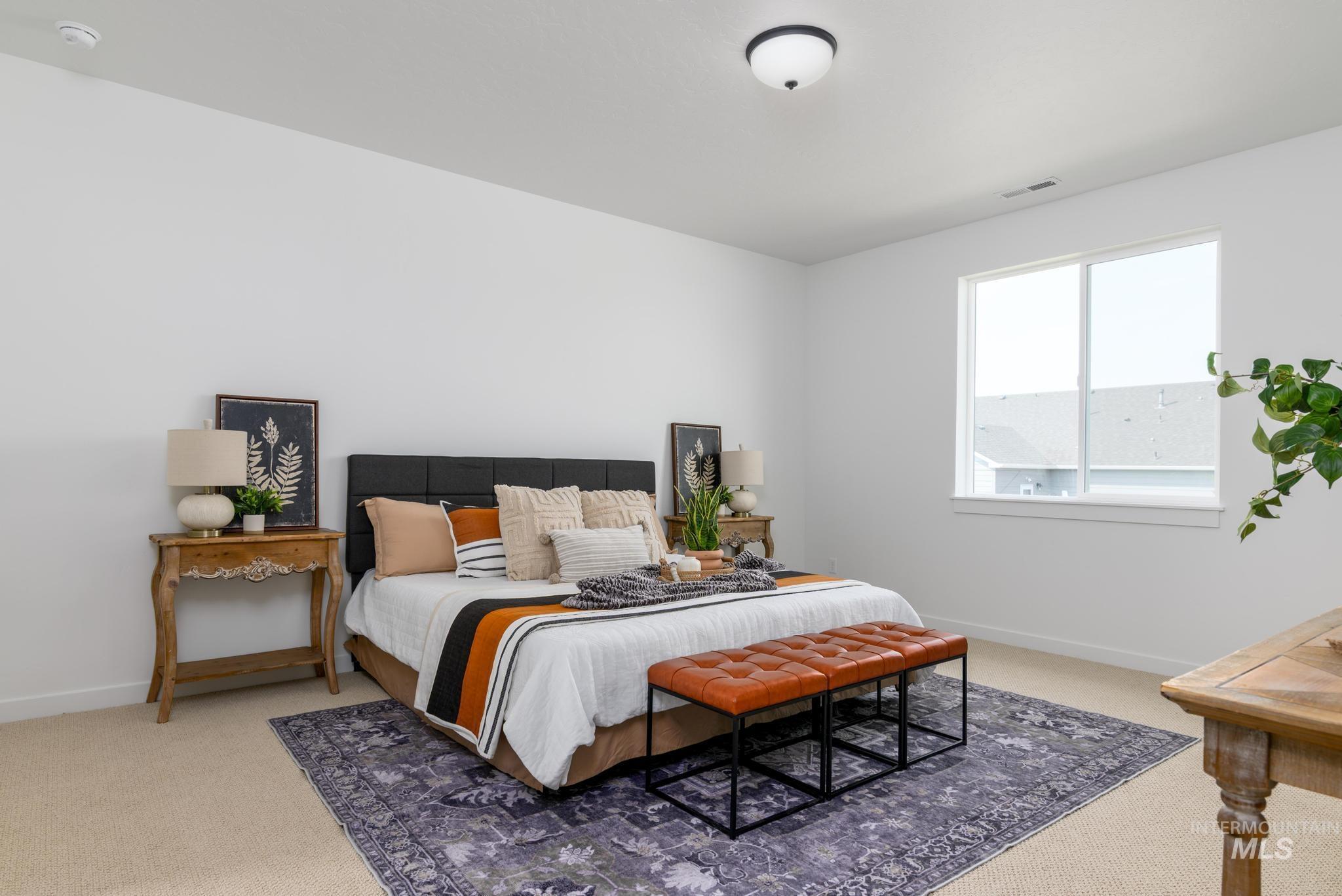 Bedroom featuring light carpet and baseboards
