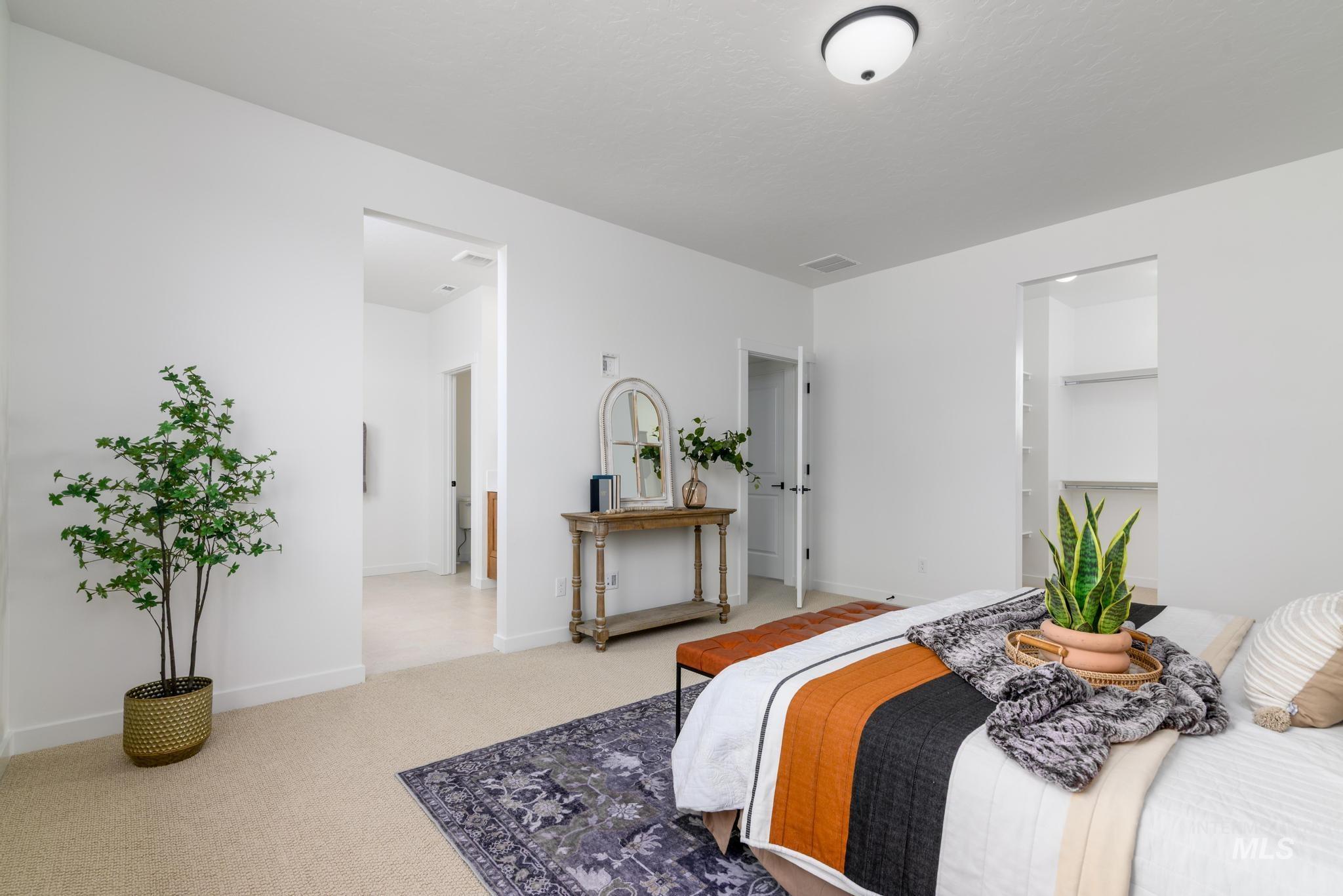 Carpeted bedroom with baseboards and a walk in closet