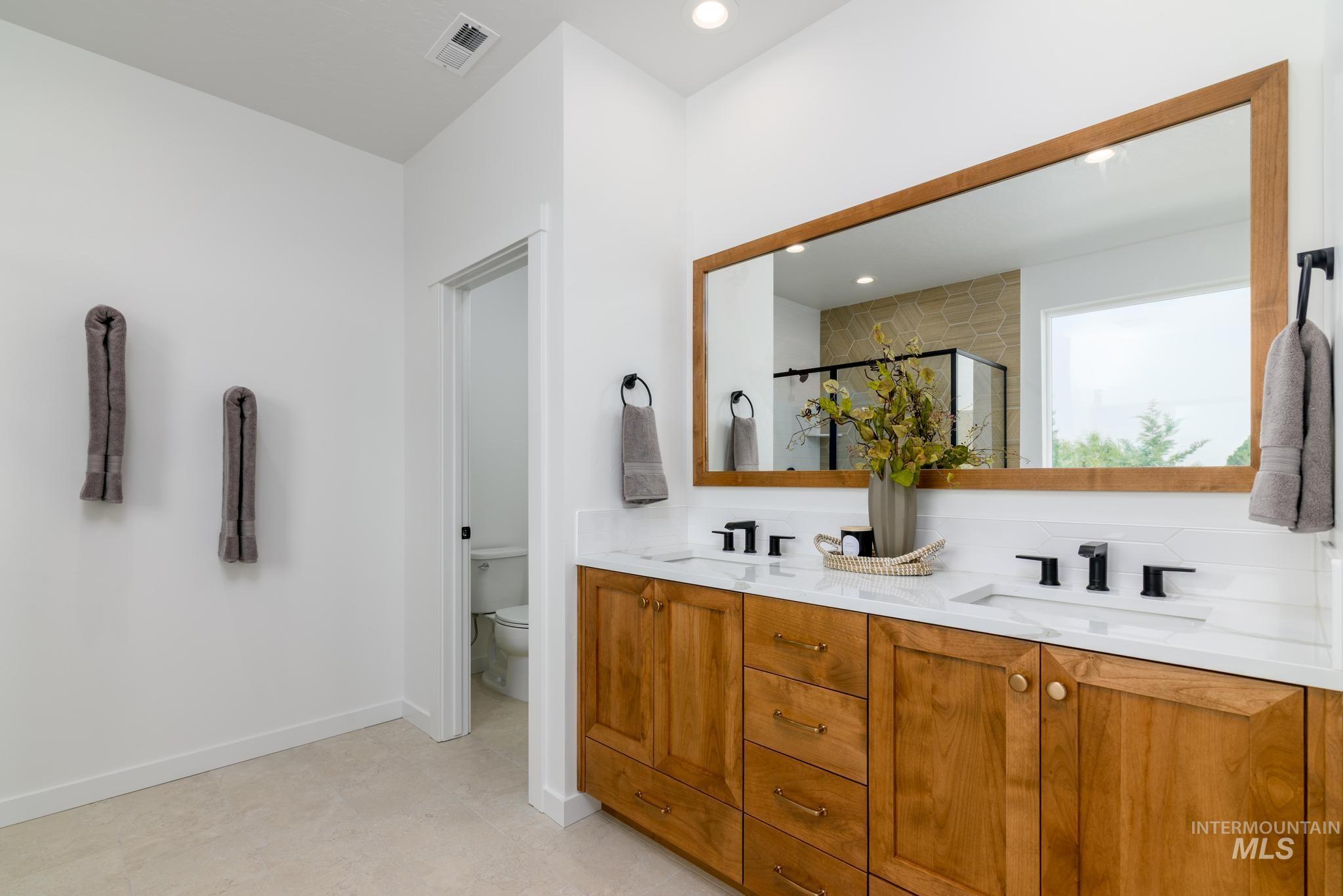 Full bathroom with a stall shower, double vanity, and recessed lighting
