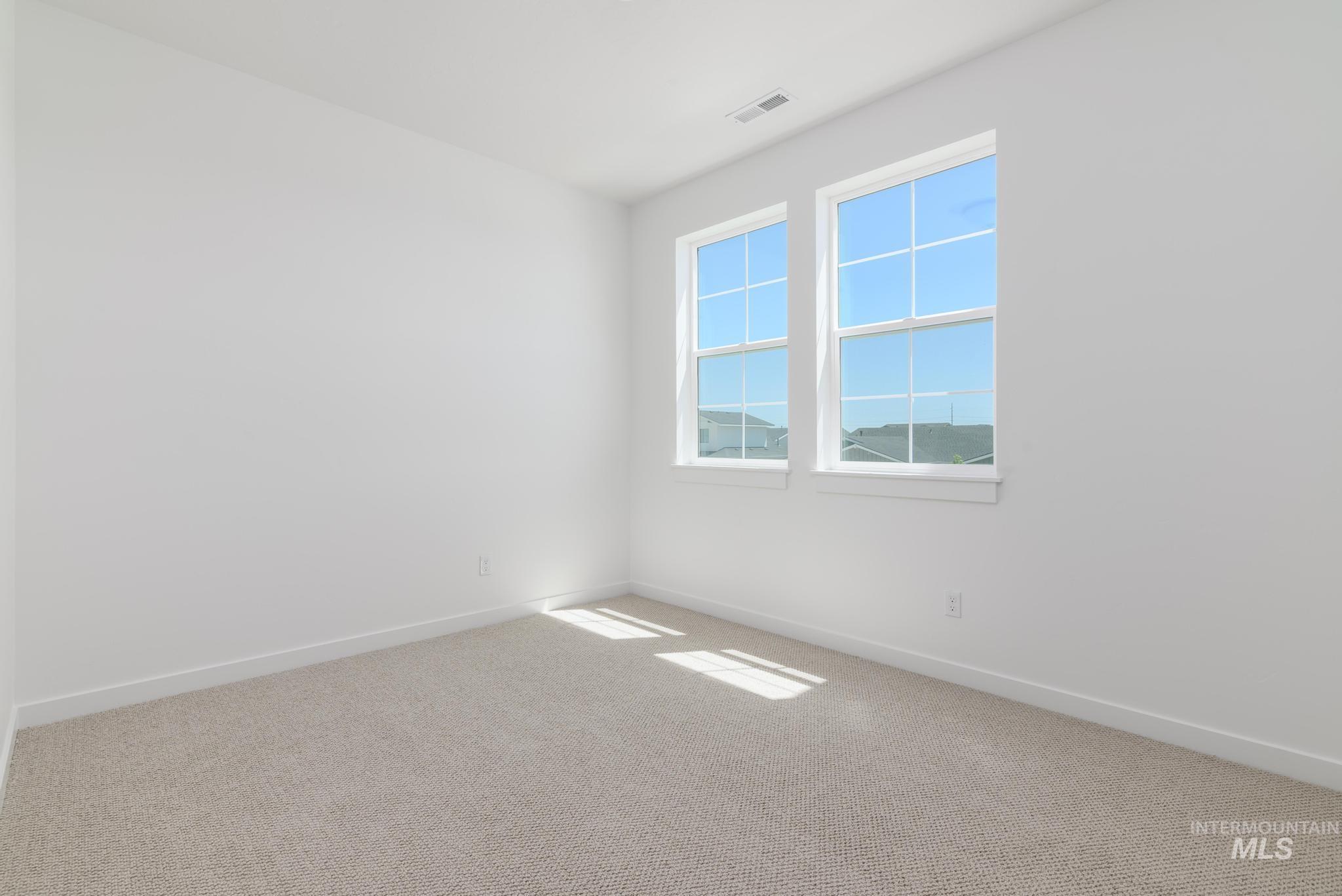 Carpeted spare room with baseboards