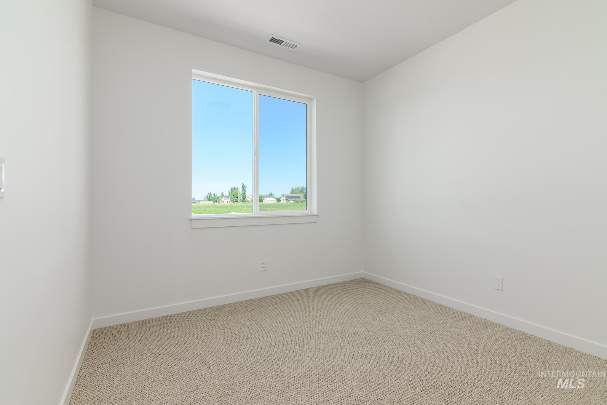 Spare room featuring carpet and baseboards