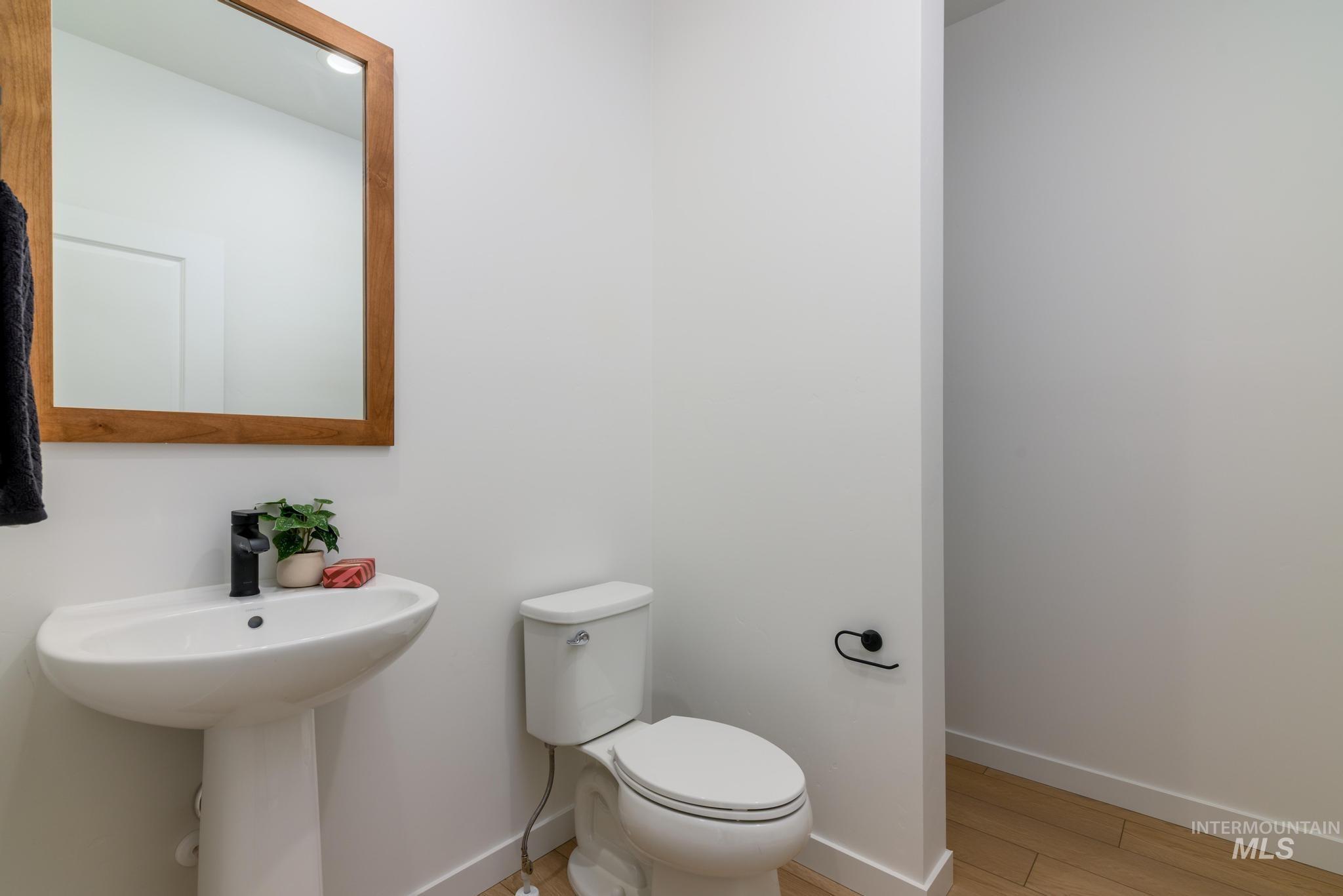 Half bathroom with baseboards and light wood-style floors