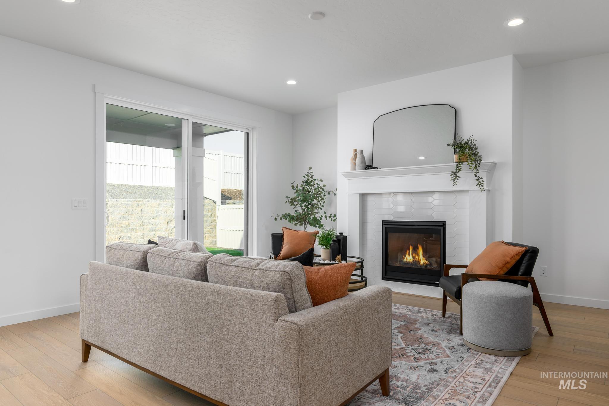 Living area with recessed lighting, light wood-style floors, and a fireplace