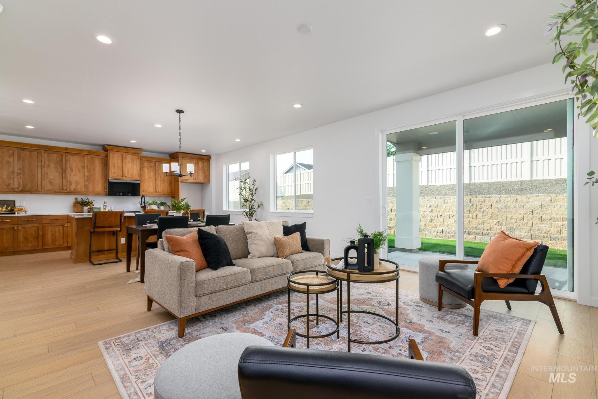 Living room with light wood-style flooring, recessed lighting, and a chandelier