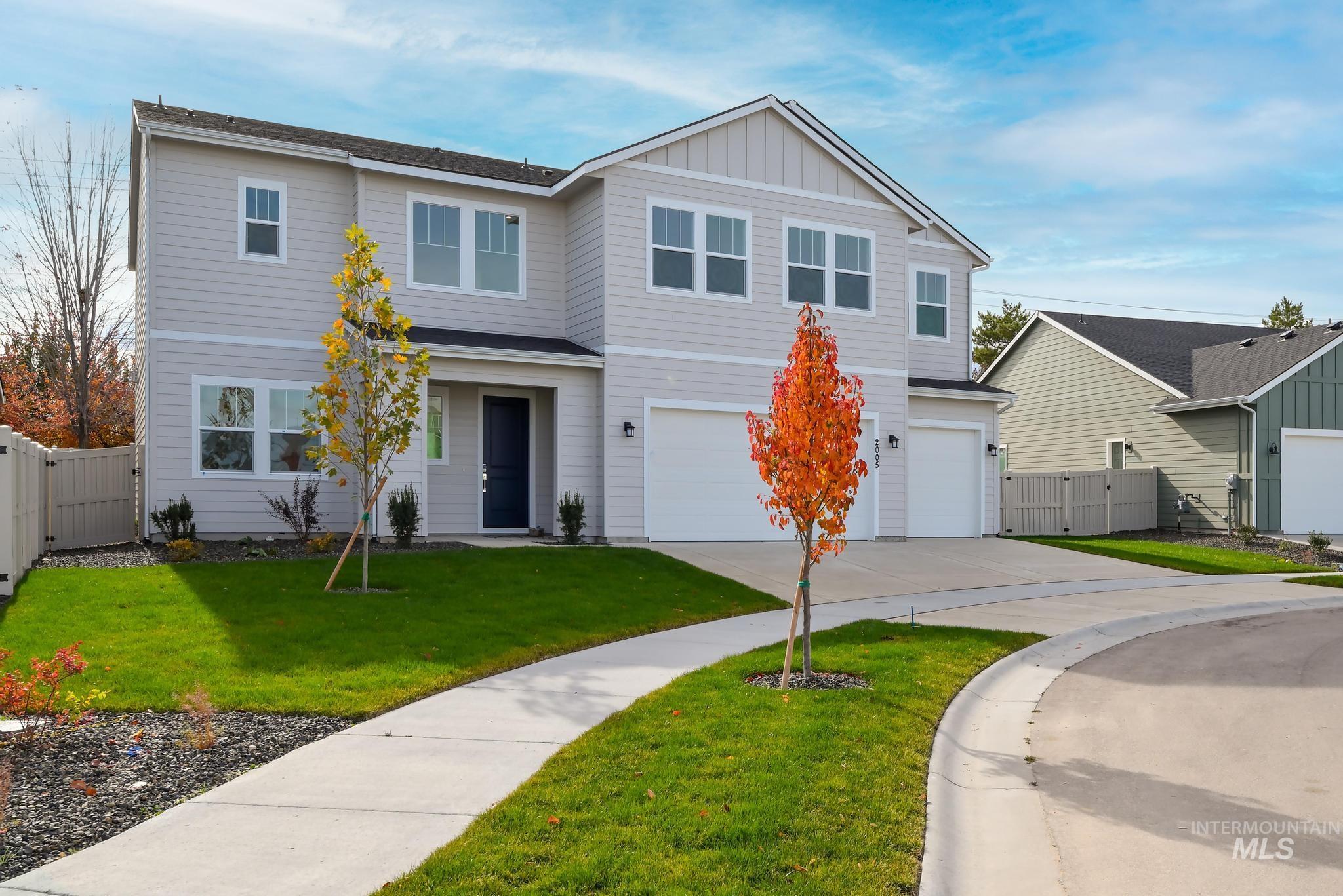 View of front facade with driveway, an attached garage, and board and batten siding