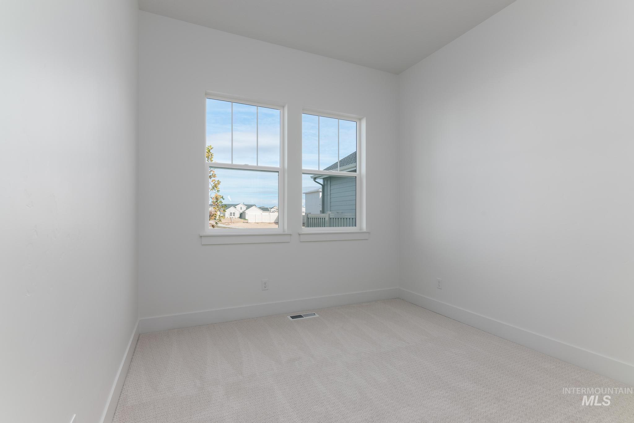 Unfurnished room featuring light colored carpet and baseboards