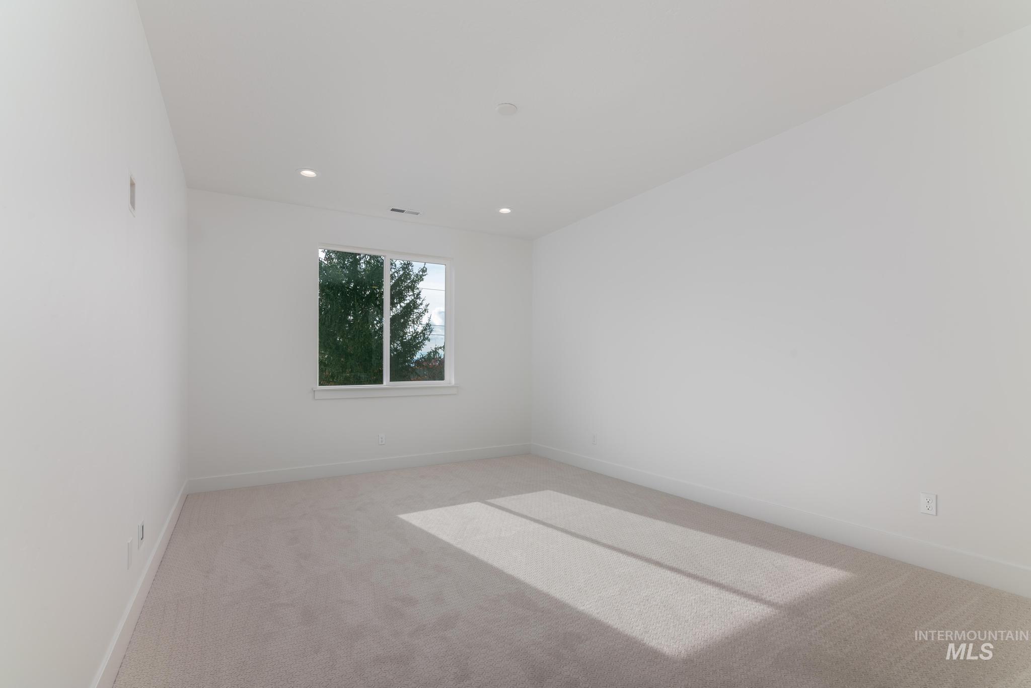 Unfurnished room with light carpet and recessed lighting
