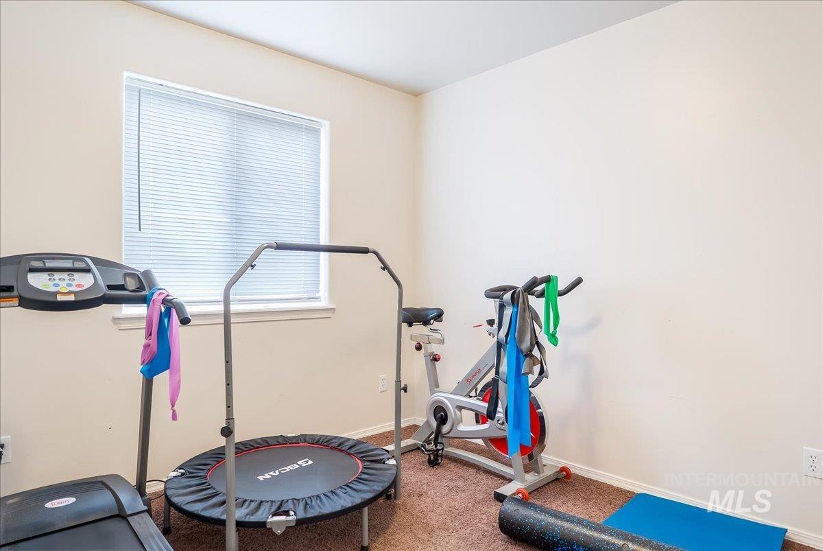 Exercise area with baseboards and carpet