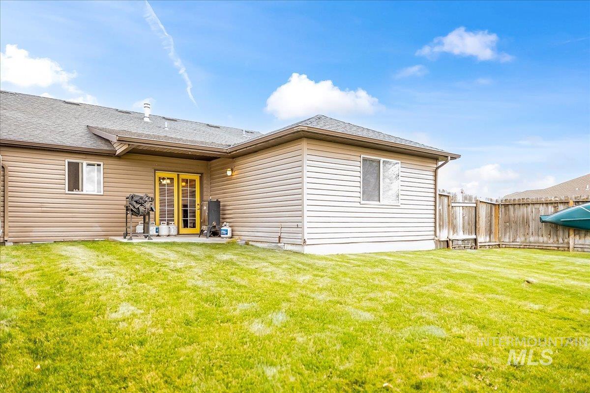 Back of house with a patio area and roof with shingles