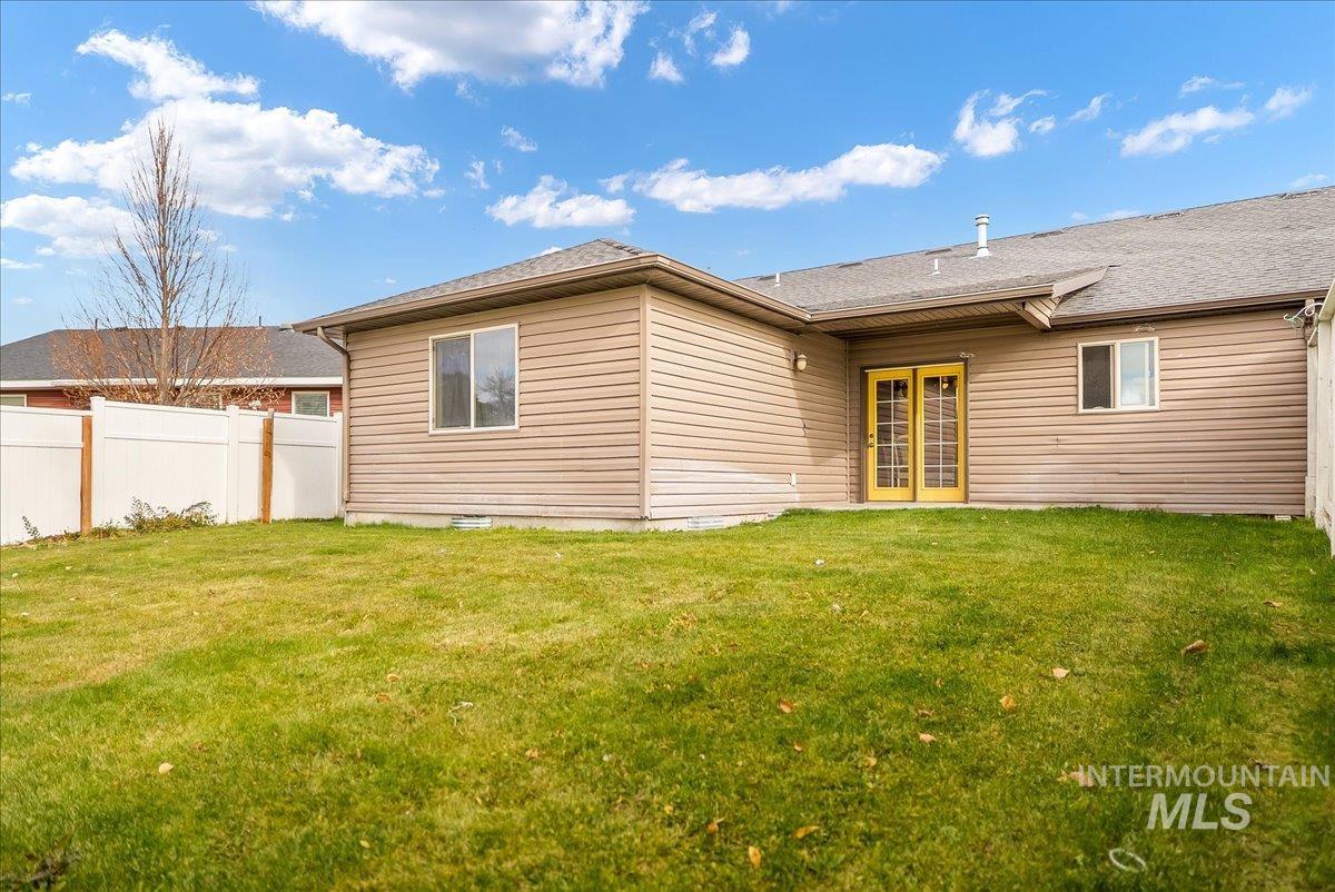 Back of property with a shingled roof, french doors, and a patio