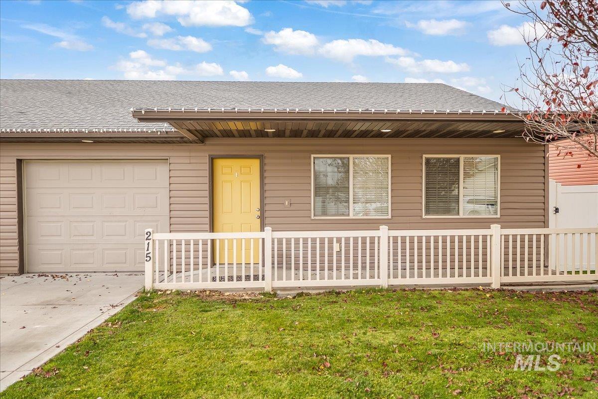 Single story home with a shingled roof, a front yard, a porch, and driveway