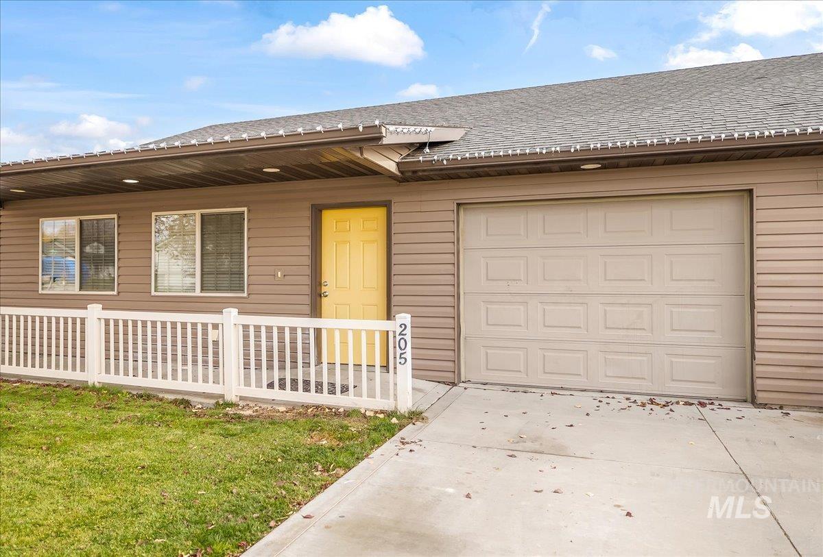 Single story home with driveway, a shingled roof, covered porch, and a front lawn