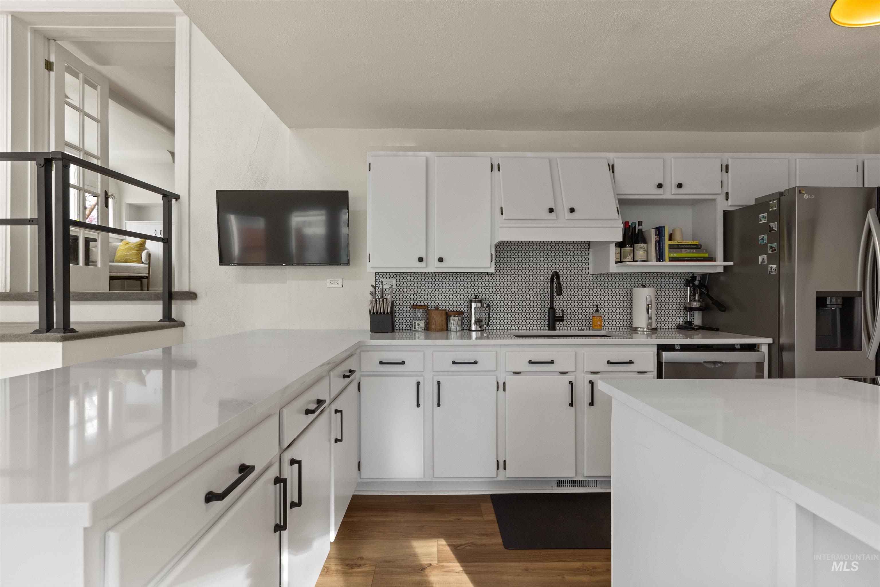 Kitchen with white cabinetry, light stone counters, backsplash, dark wood-style flooring, and open shelves