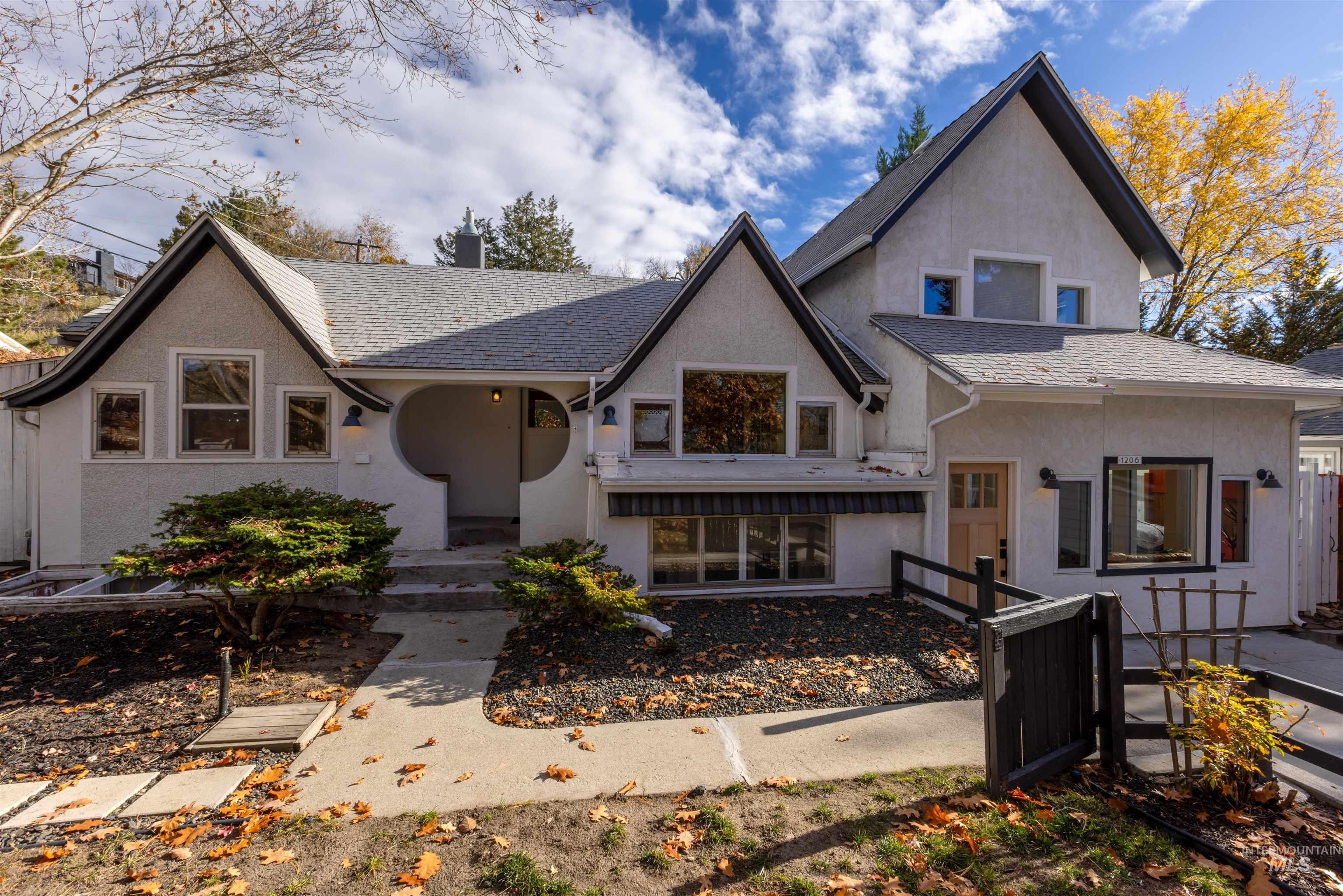 View of front of home with stucco siding and a chimney