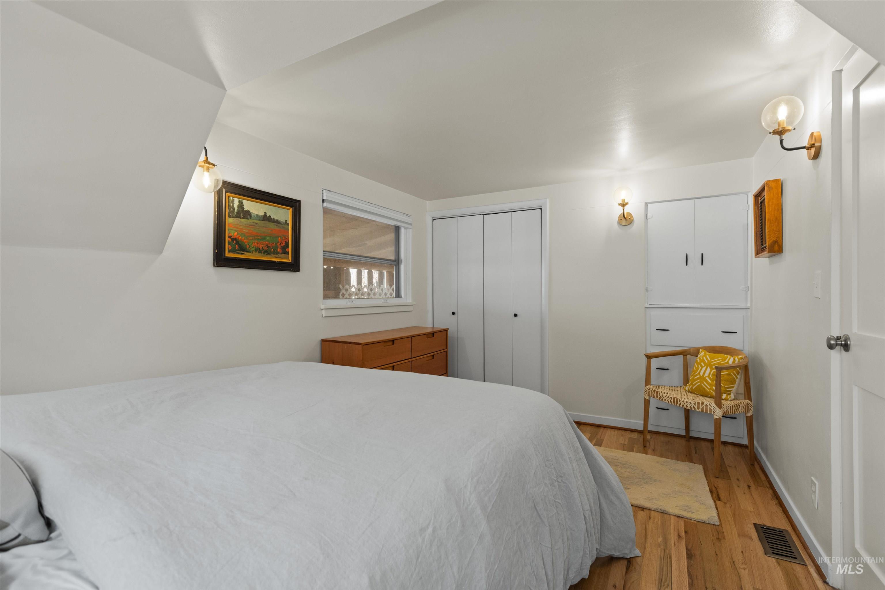 Bedroom with wood finished floors and a closet