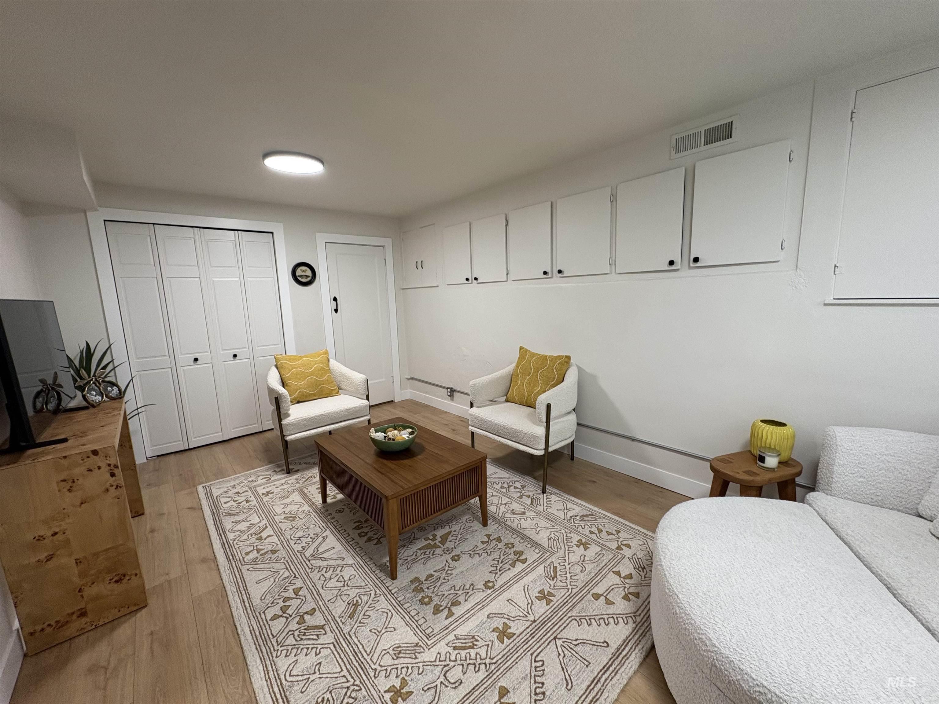 Living area featuring light wood-style floors and baseboards