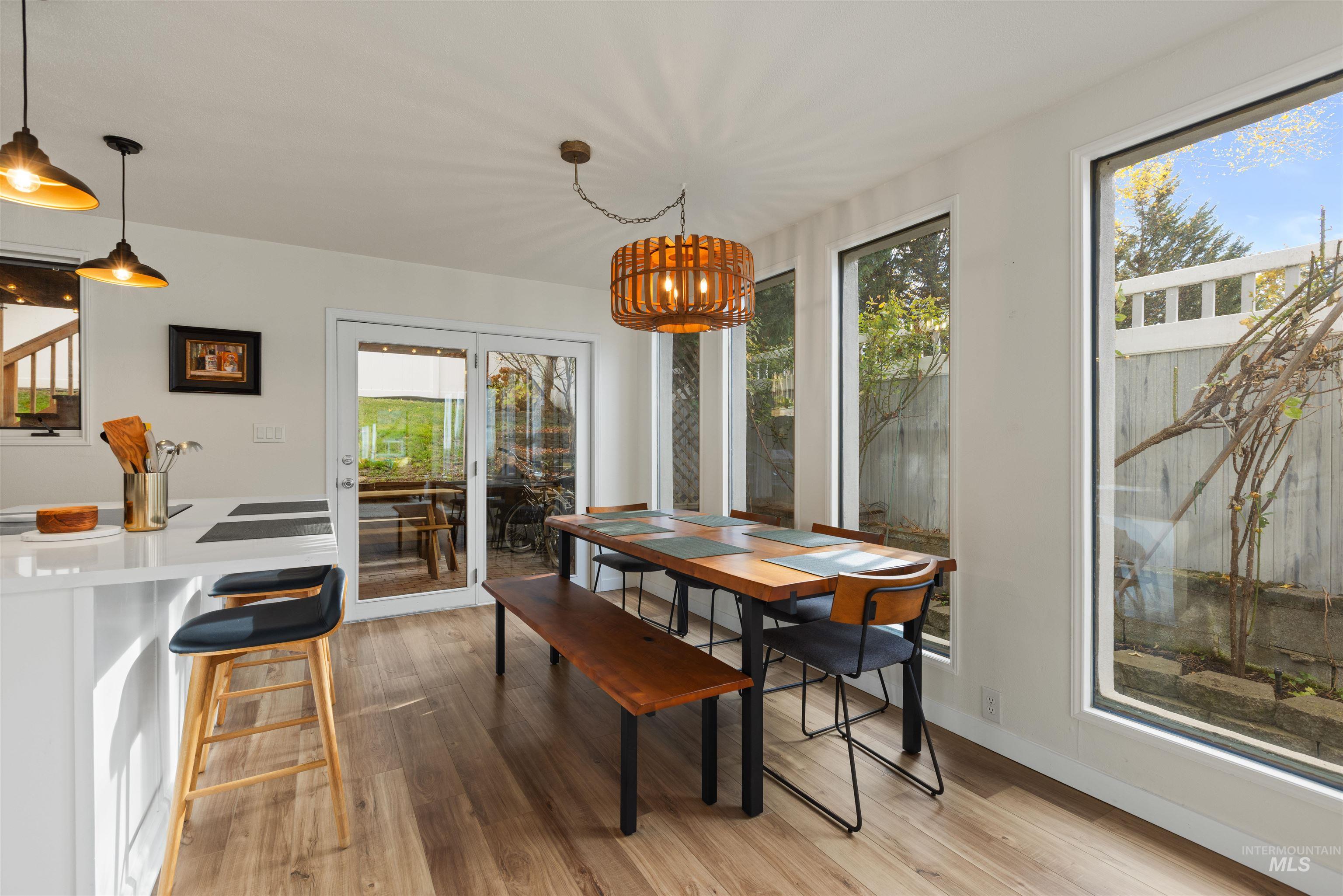 Dining space with light wood-type flooring, plenty of natural light, and a chandelier