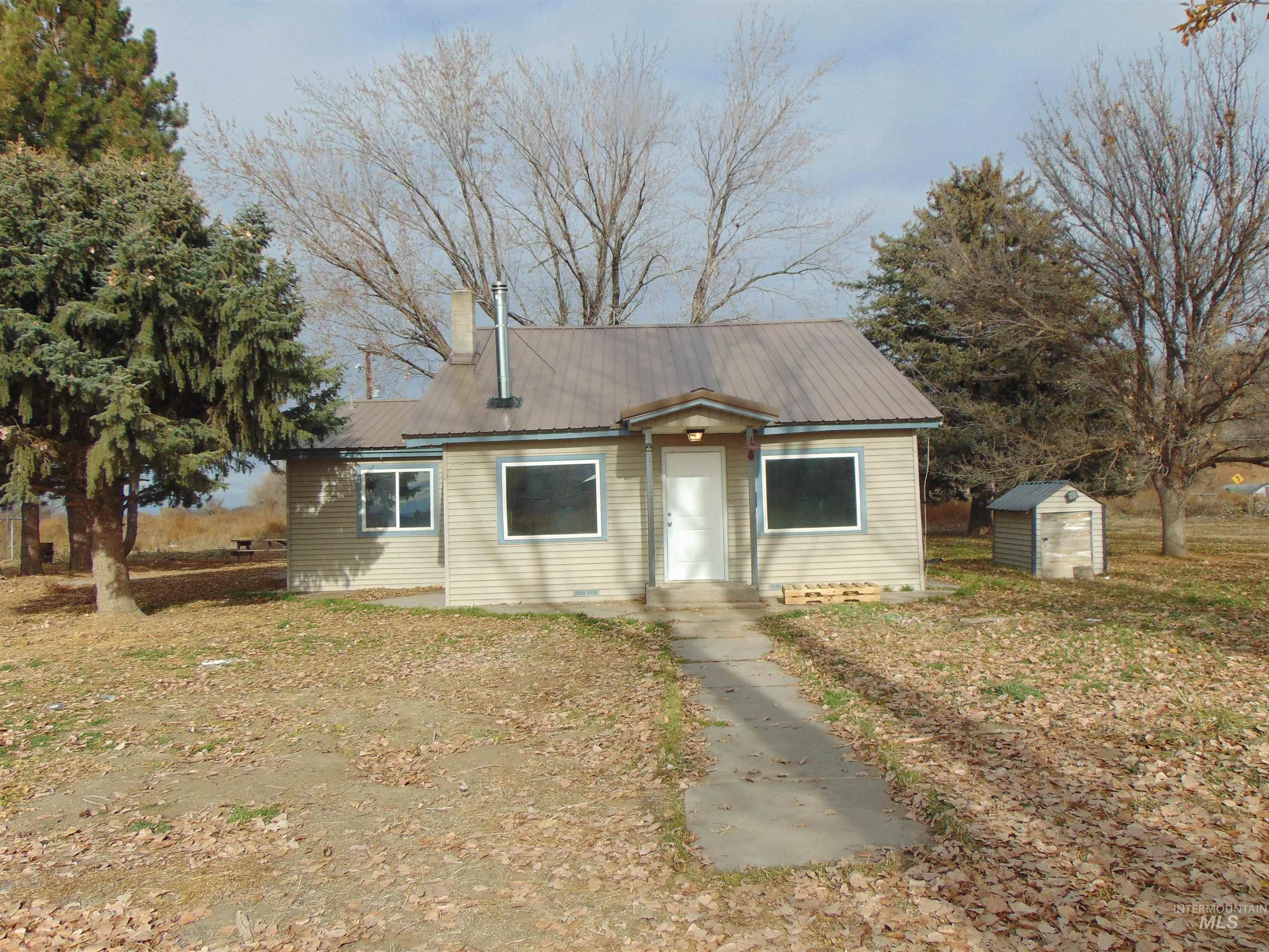 Bungalow-style home with a storage shed and a metal roof