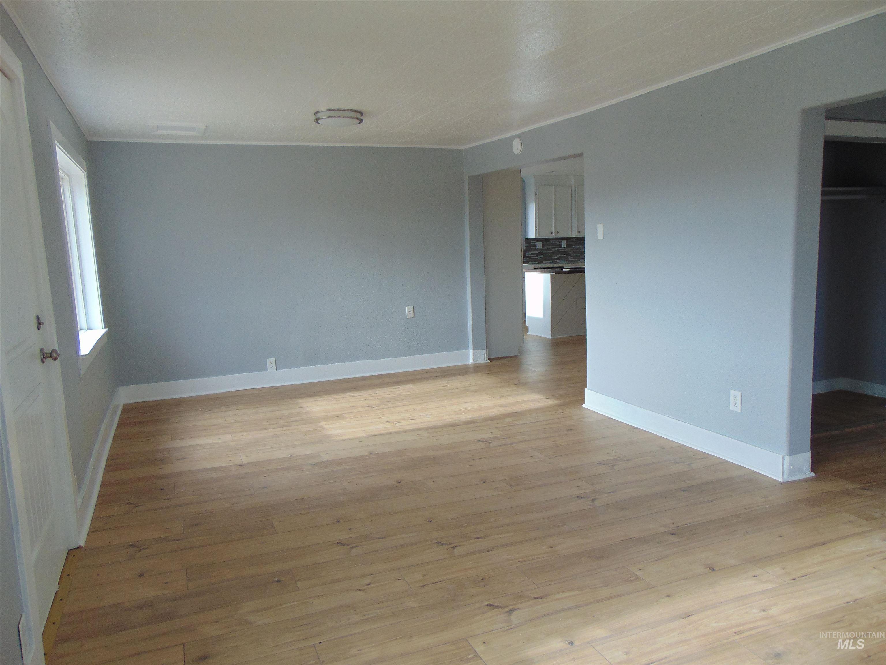 Spare room featuring light wood-style flooring and crown molding