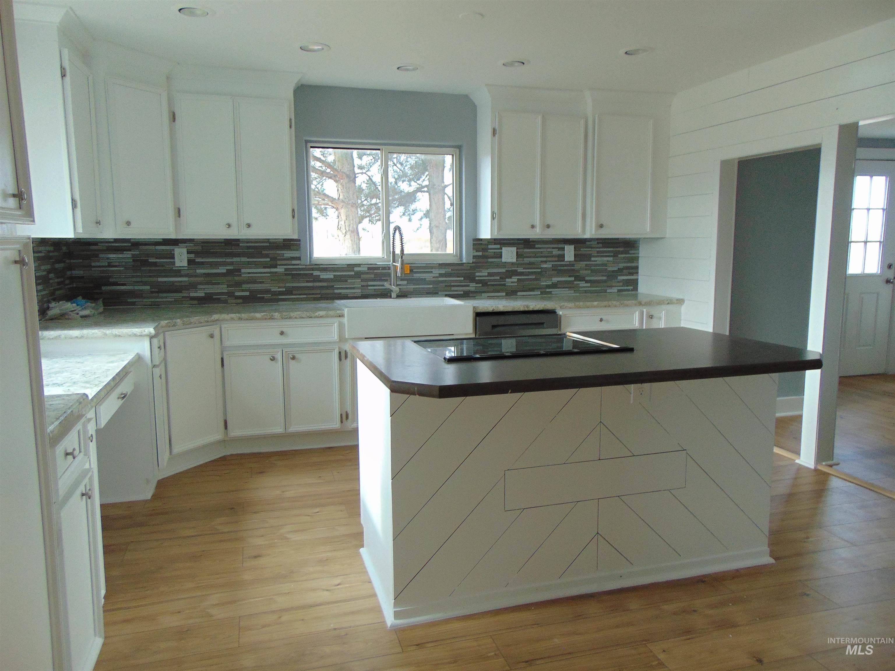 Kitchen featuring a kitchen island, white cabinetry, healthy amount of natural light, and recessed lighting