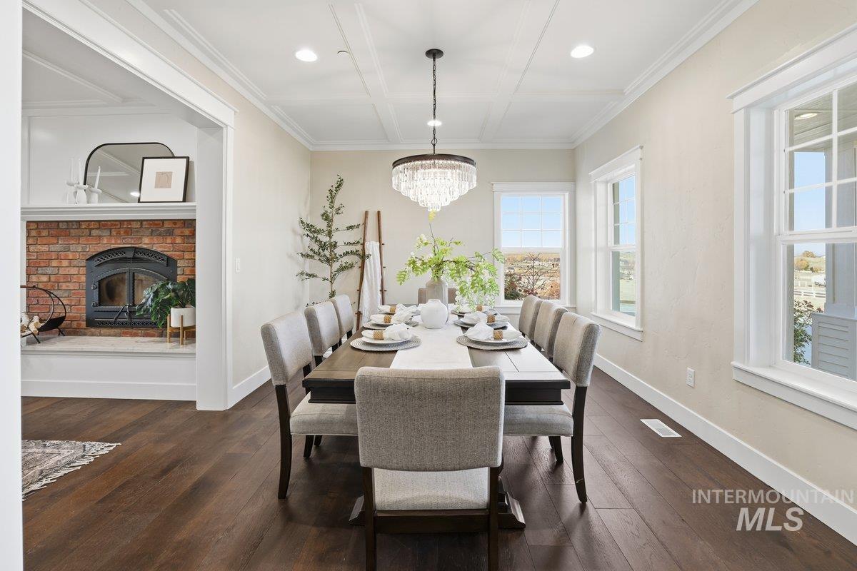 Bar area with dark wood finished floors, coffered ceiling, recessed lighting, and ornamental molding.