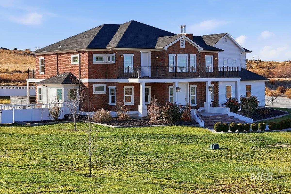 View of front of property with a front yard, brick siding, and a porch