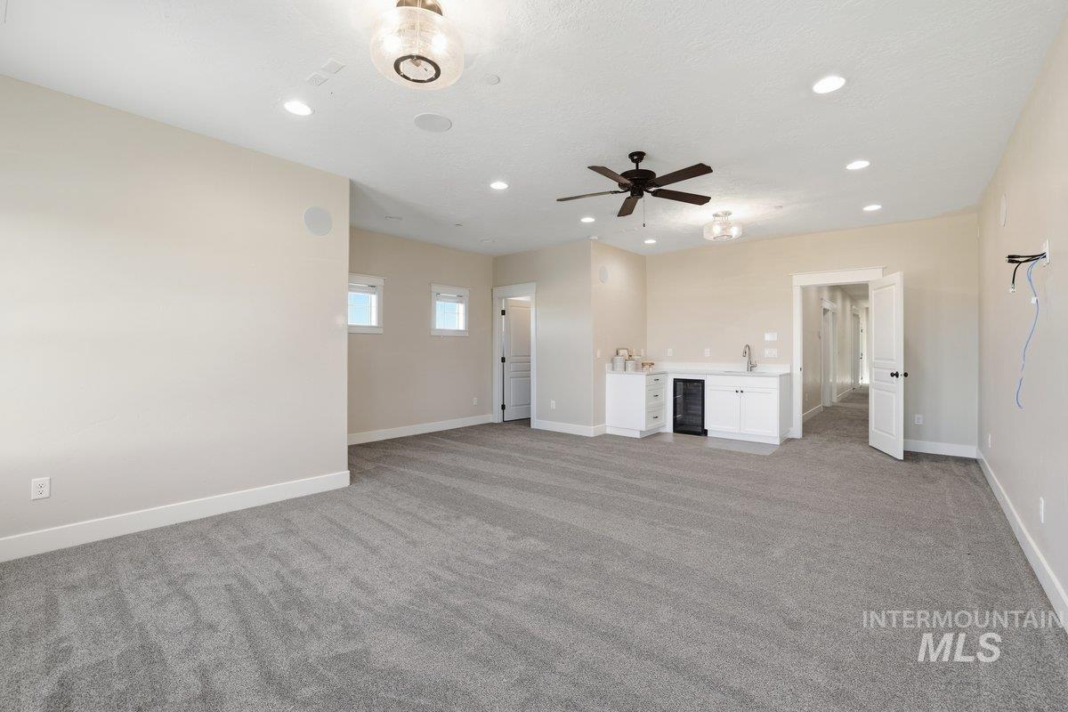 Bonus room featuring light colored carpet, recessed lighting, beverage cooler, and a ceiling fan