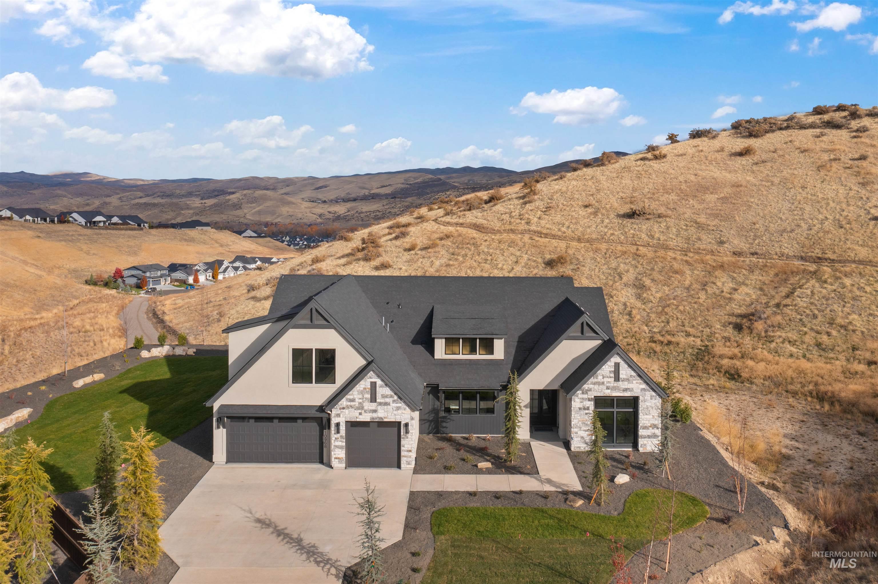 View of front of home with stone siding, driveway, a garage, and stucco siding