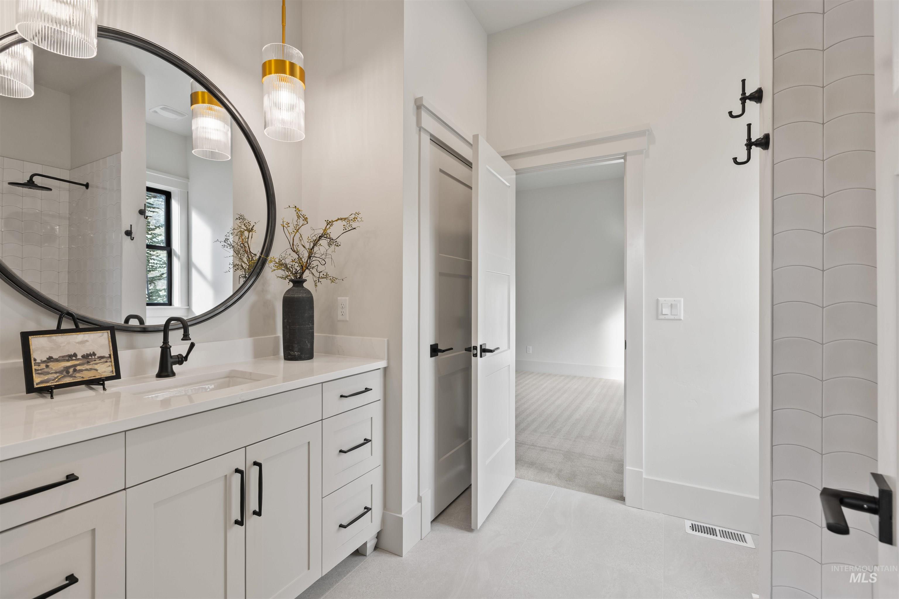 Bathroom with vanity, light colored carpet, and a tile shower