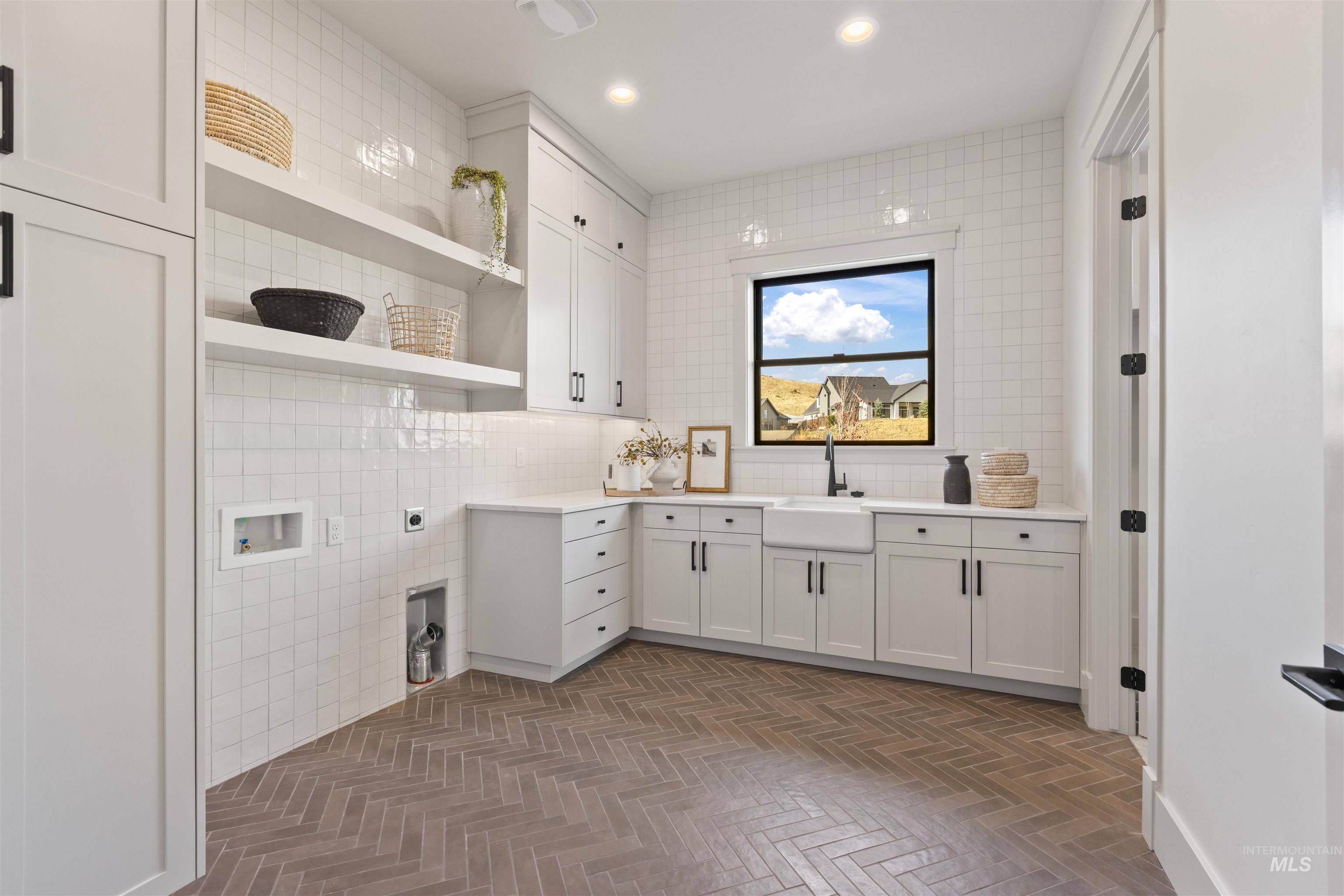 Laundry area with tile walls, washer hookup, cabinet space, electric dryer hookup, and recessed lighting