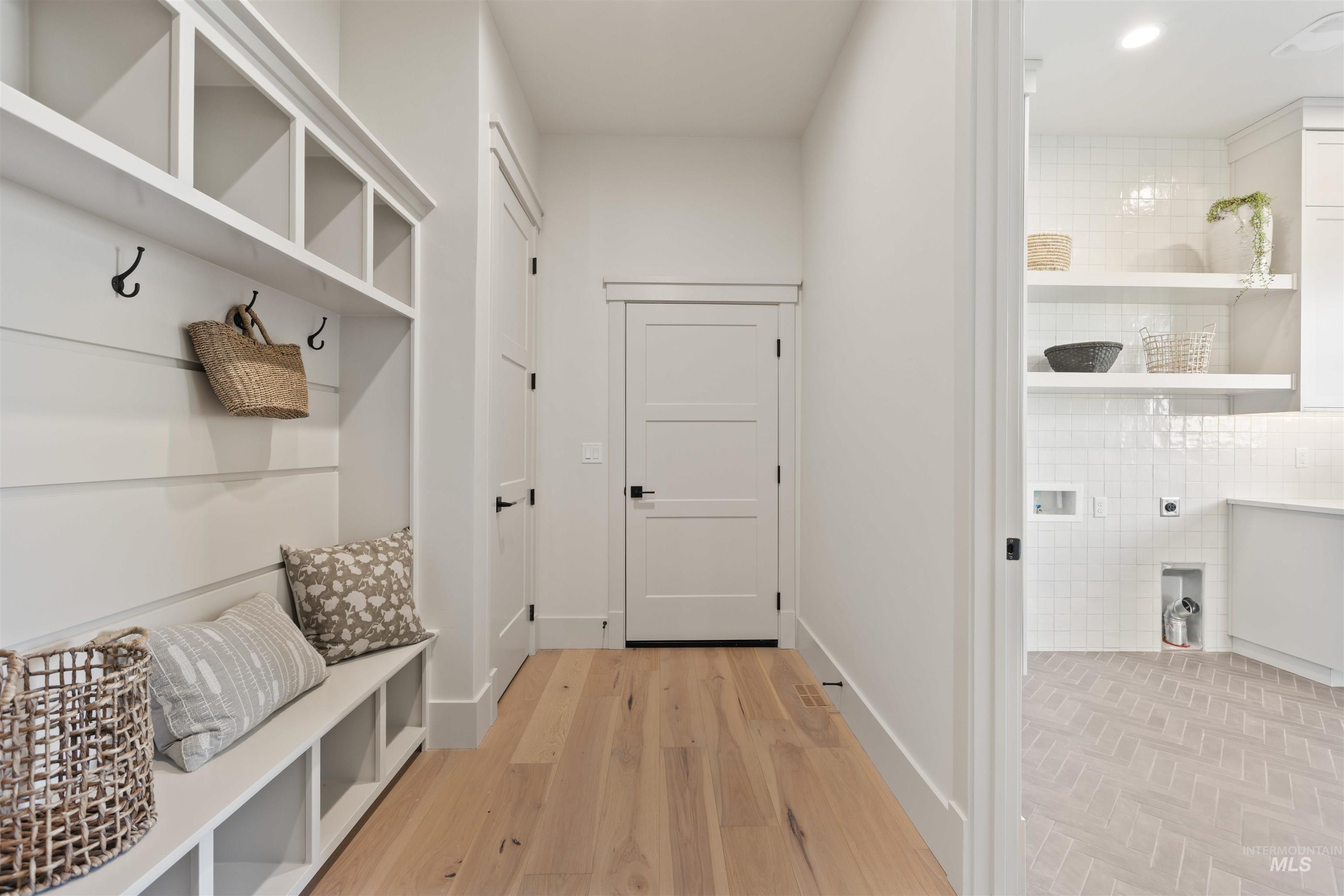 Mudroom featuring light wood-style floors and baseboards