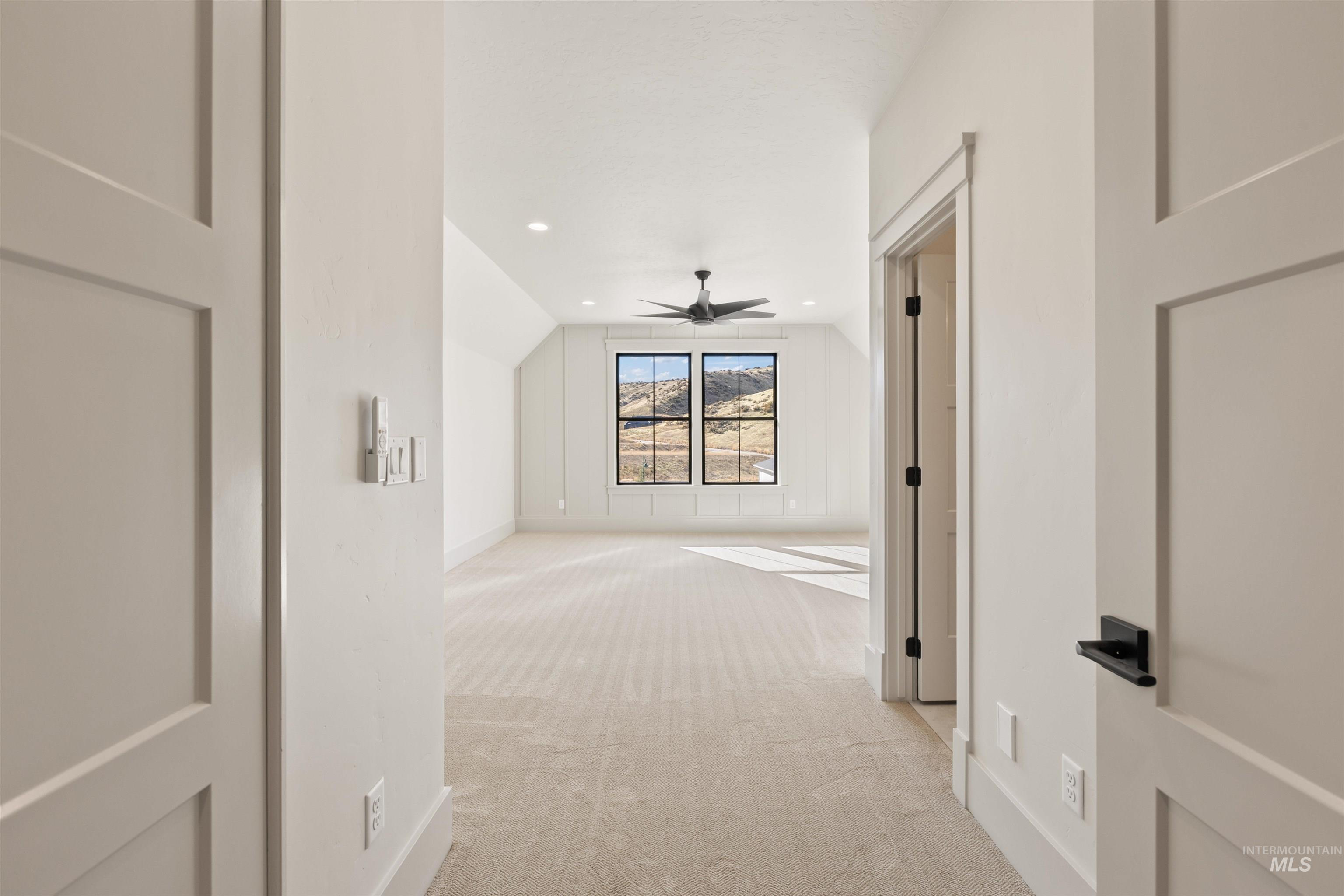 Hallway featuring light colored carpet, recessed lighting, and vaulted ceiling