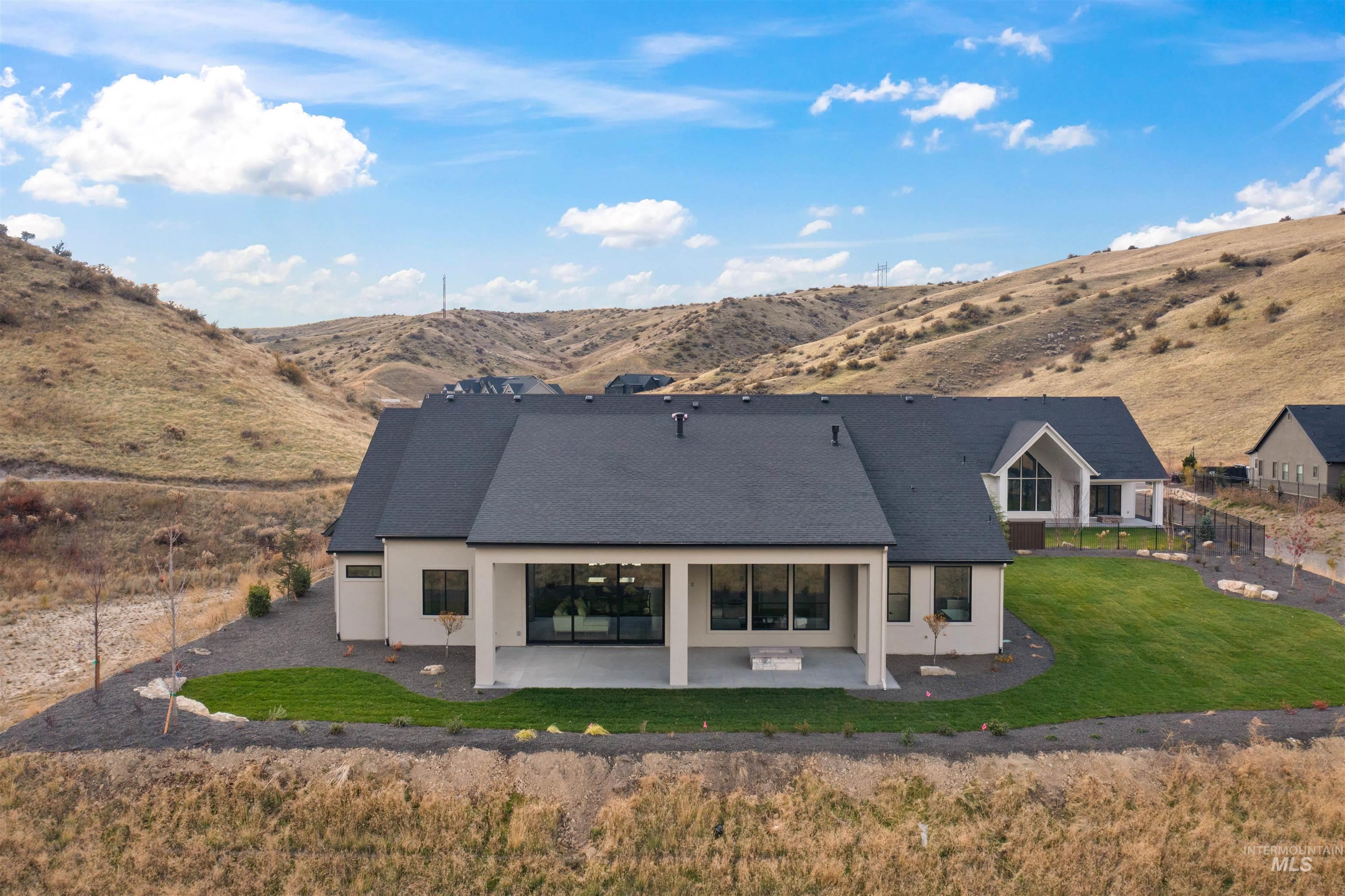 Rear view of property featuring a patio, a mountain view, stucco siding, and a yard