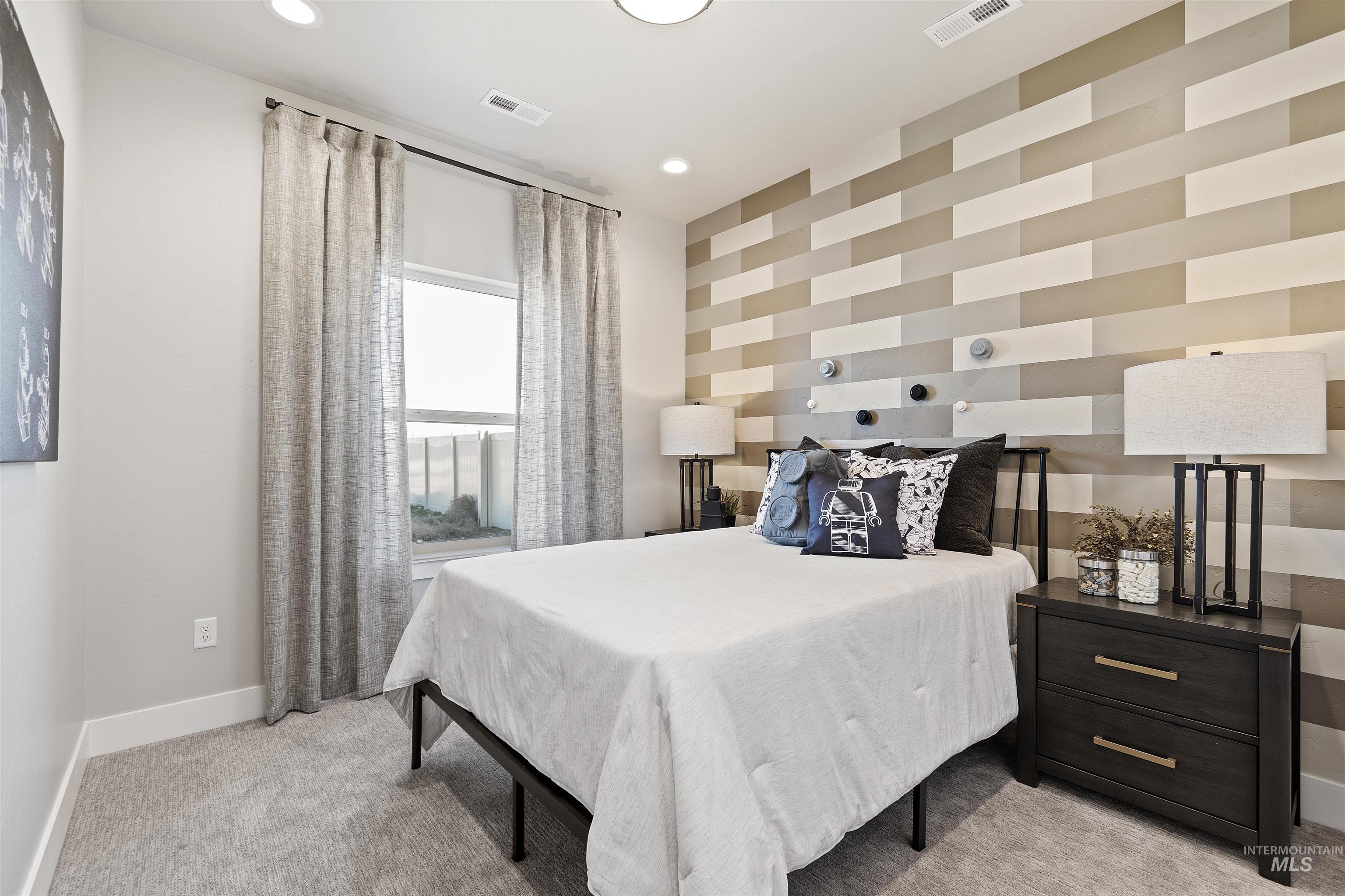 Bedroom featuring light carpet, an accent wall, and recessed lighting