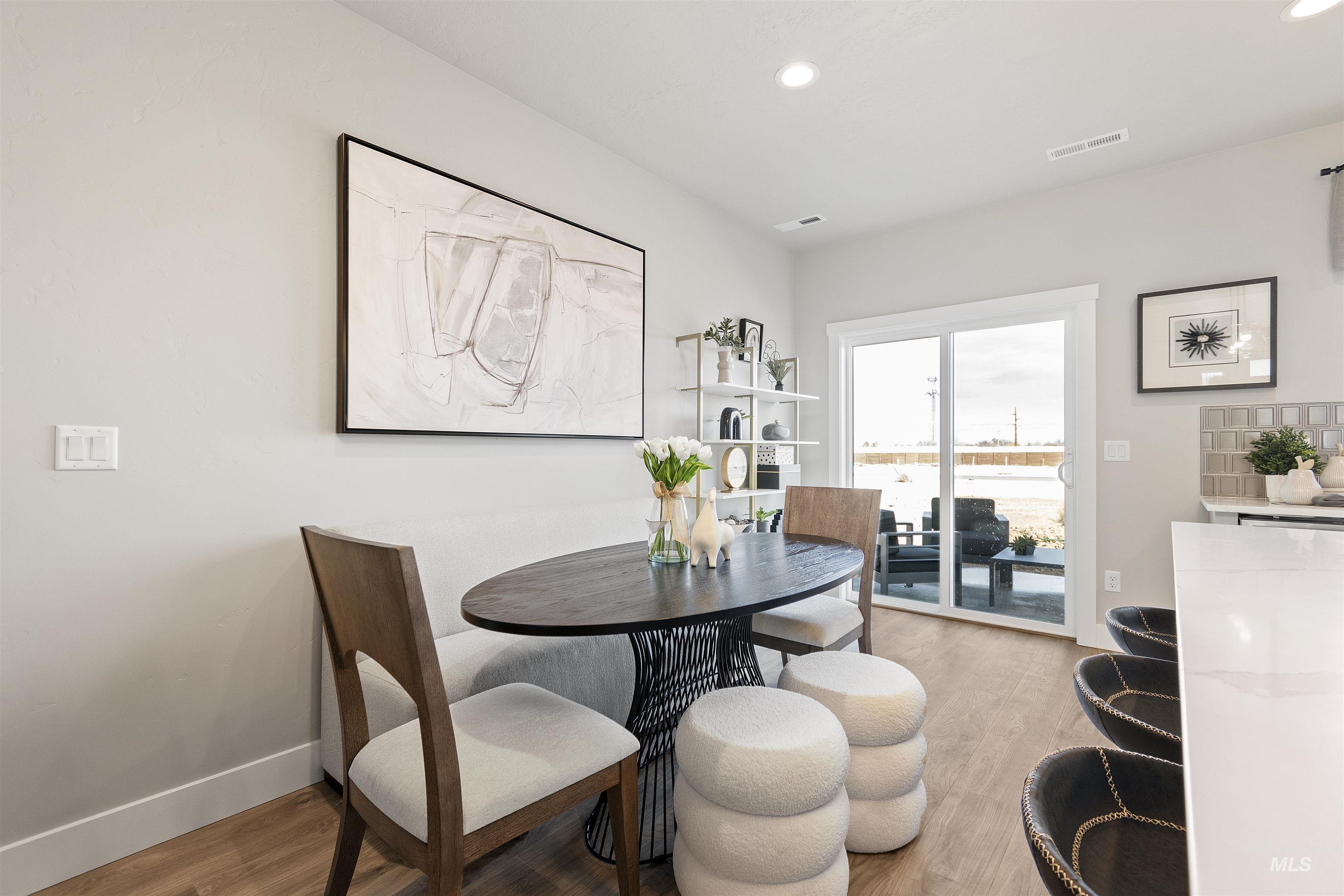 Dining space with light wood-style floors and recessed lighting