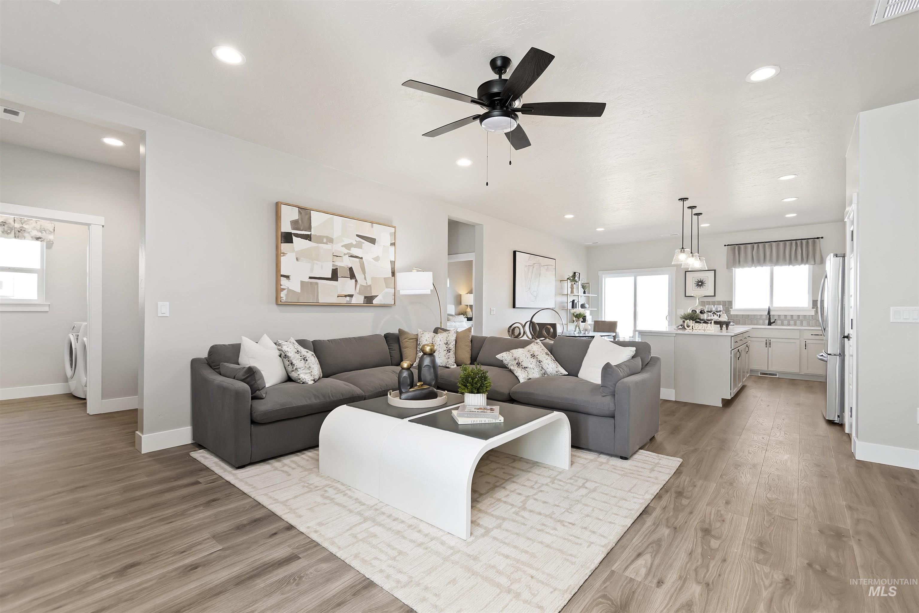 Living area with light wood finished floors, recessed lighting, and ceiling fan